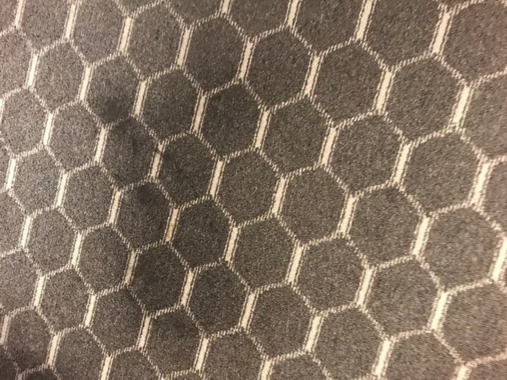 A close up of a carpet with a honeycomb pattern.