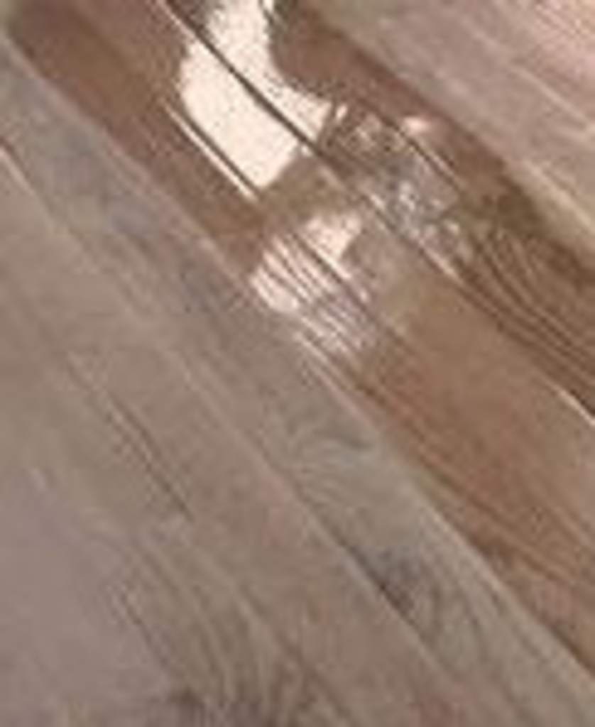 A close up of a wooden floor with a shiny finish.