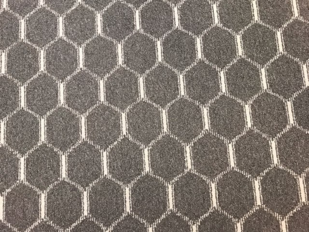 A close up of a carpet with a honeycomb pattern on it.