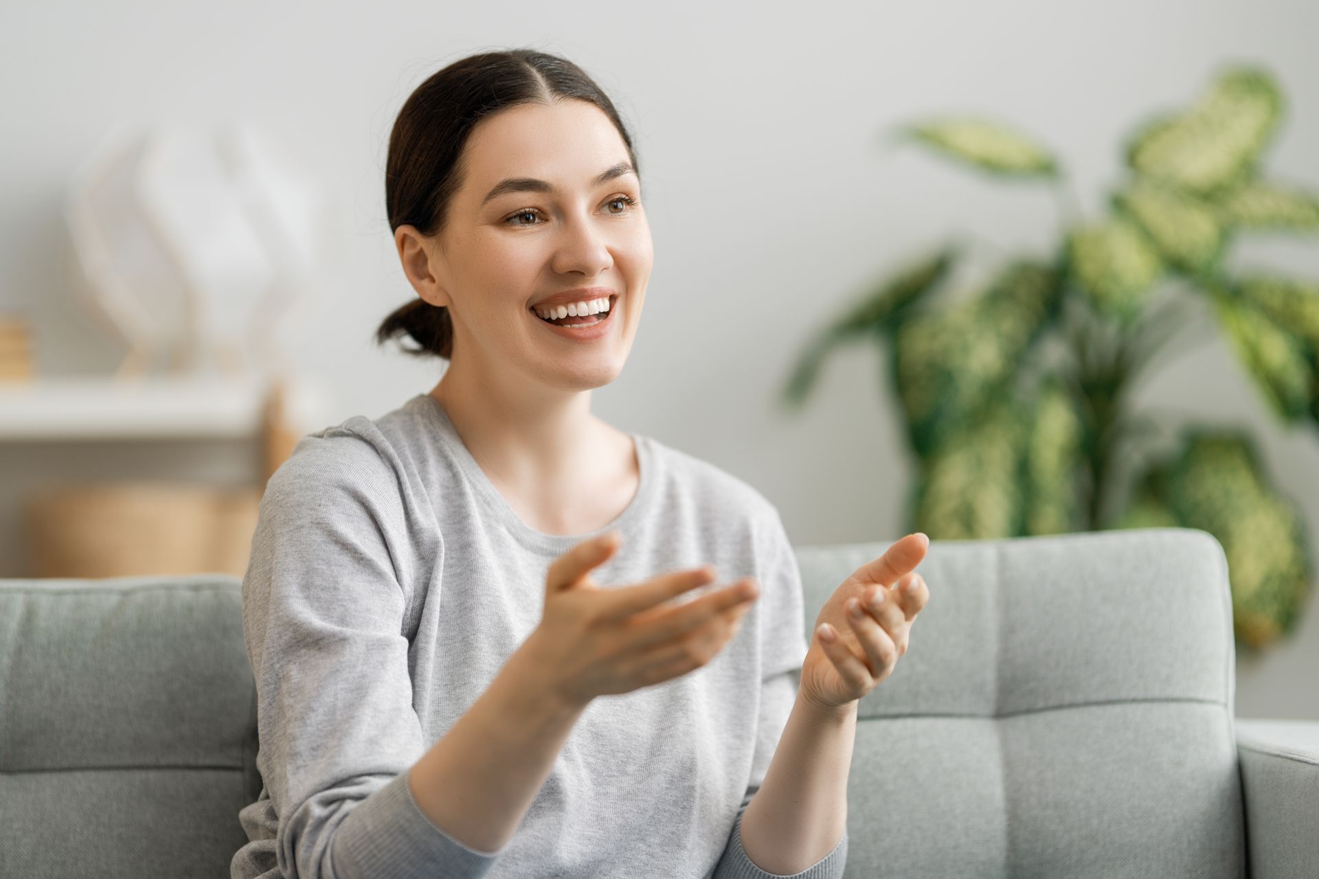 A woman is sitting in a lotus position on a yoga mat next to candles.
