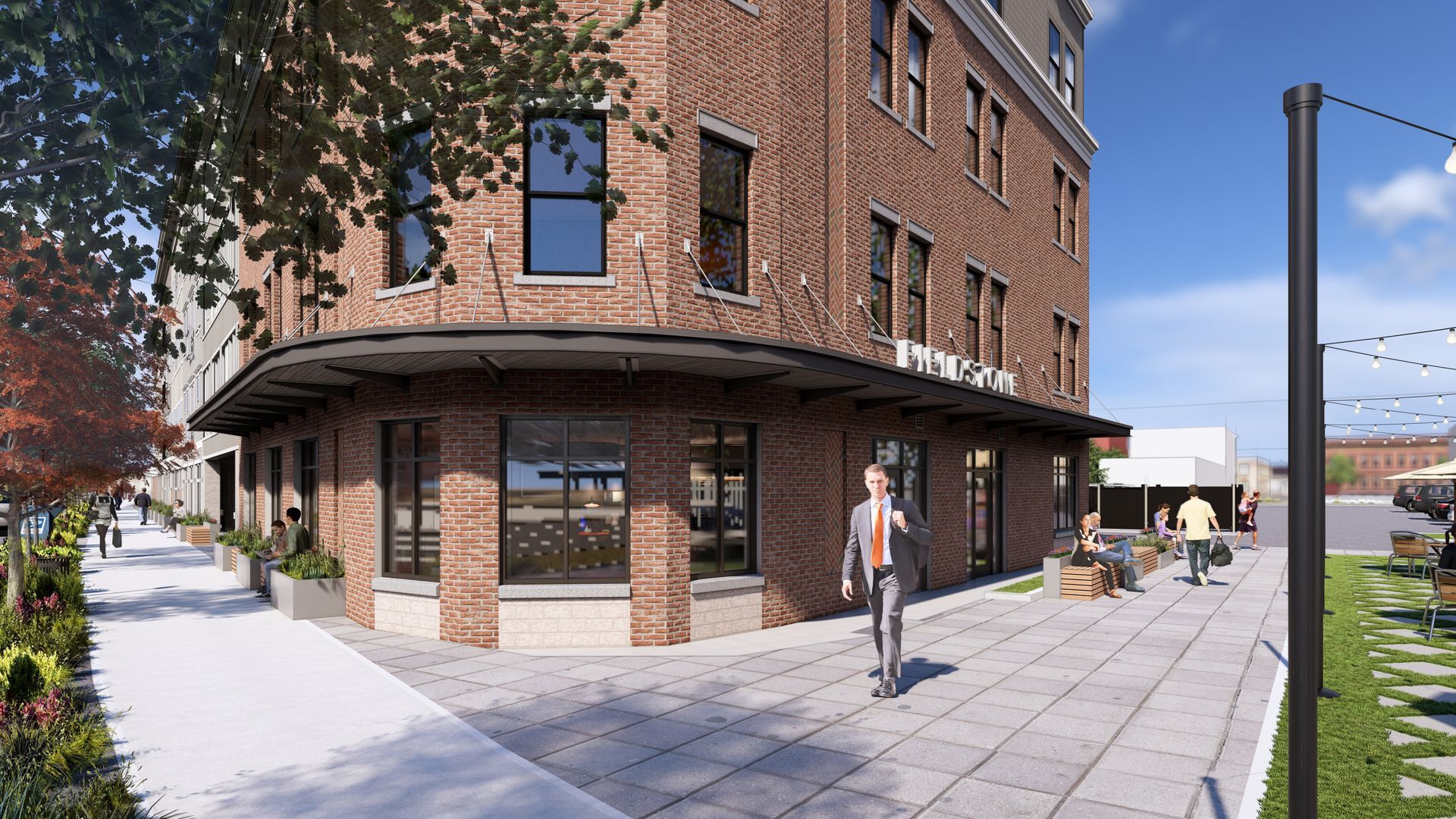 Brick building on a corner lot with sidewalk and a person walking towards the camera.