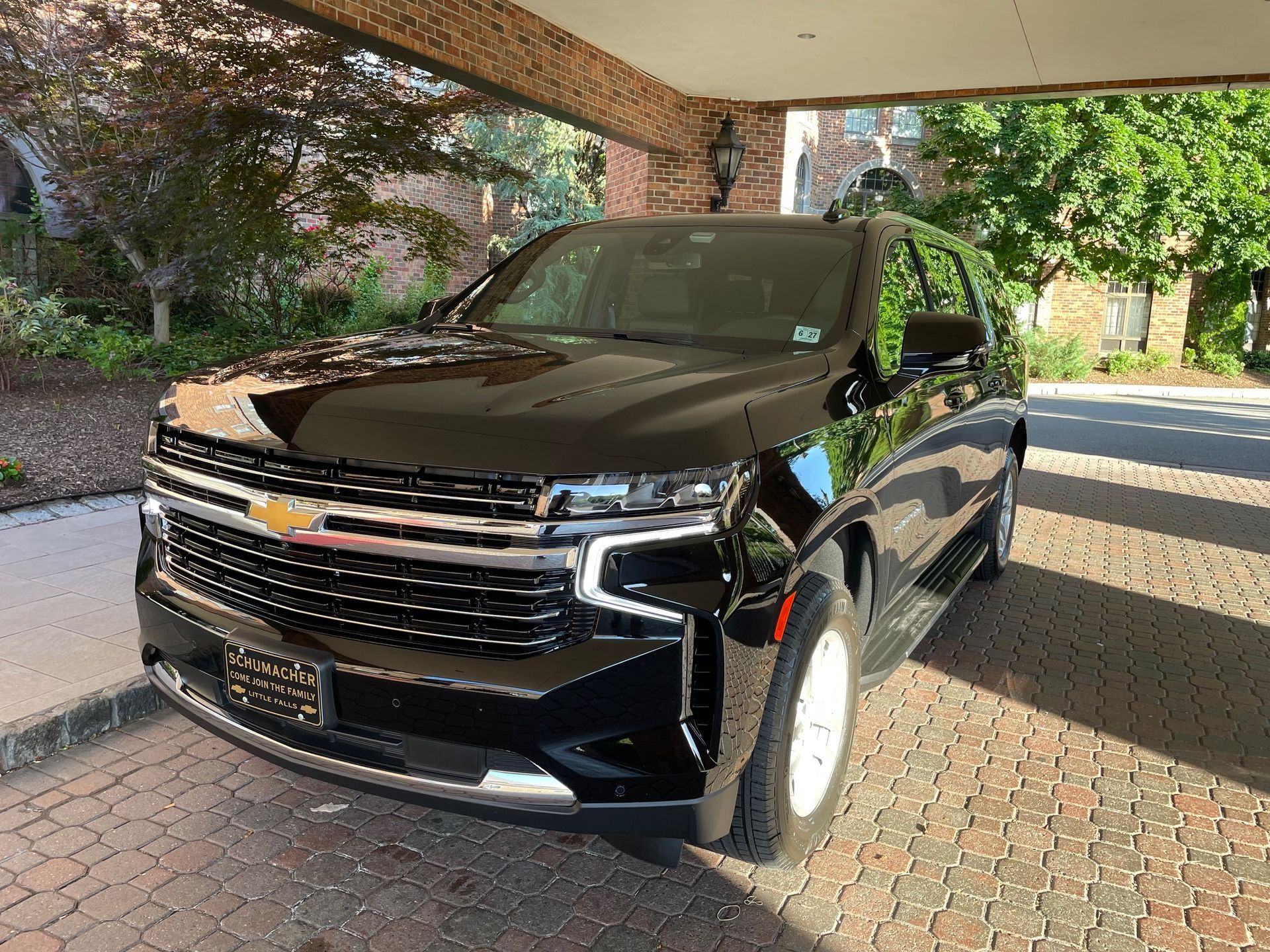 Black Chevrolet SUV parked under a covered brick entryway.