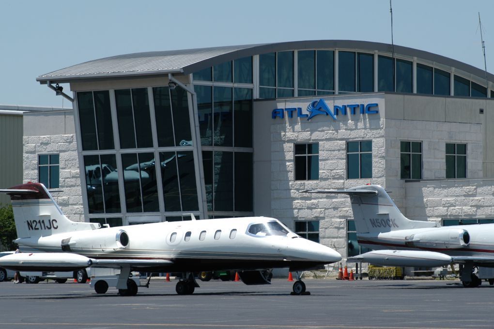 Jets parked in front of Atlantic Aviation building; blue logo on exterior.