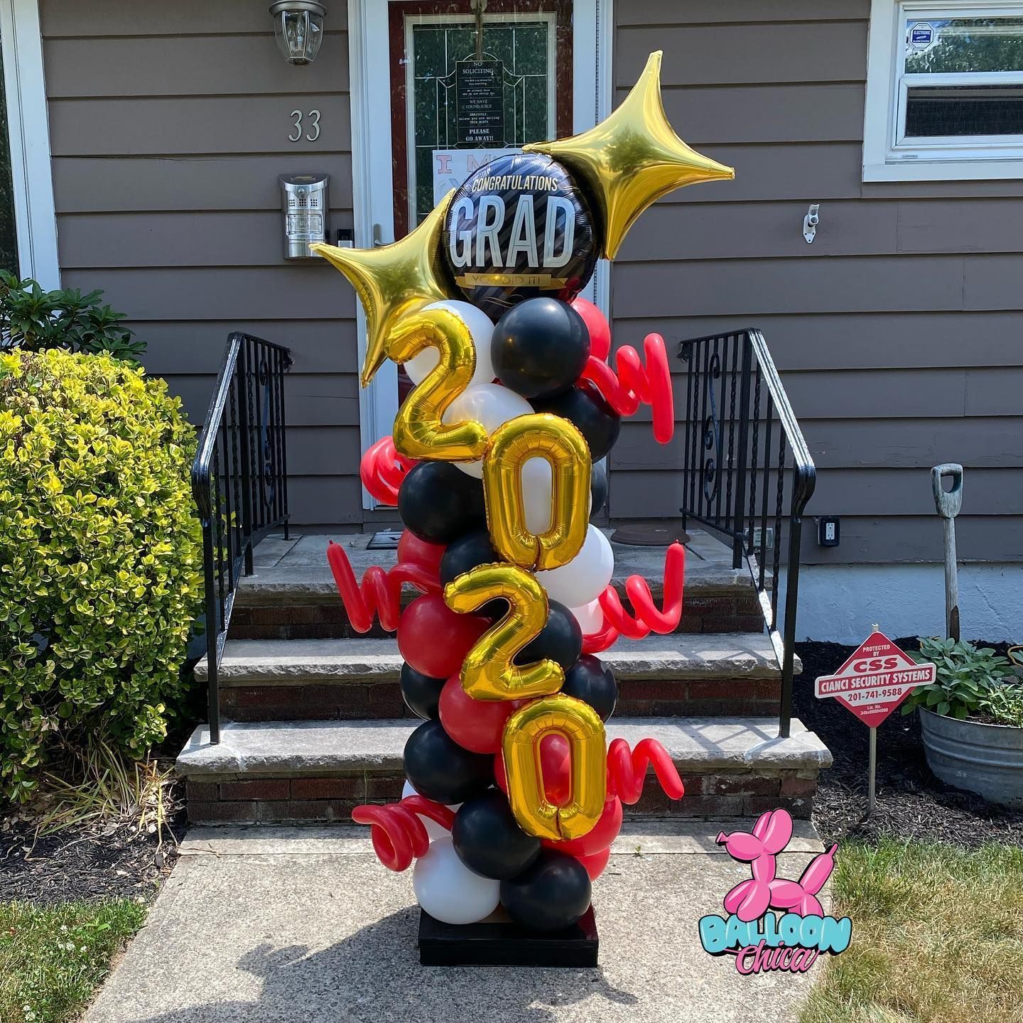 a balloon tower with the year 2020 on it is in front of a house