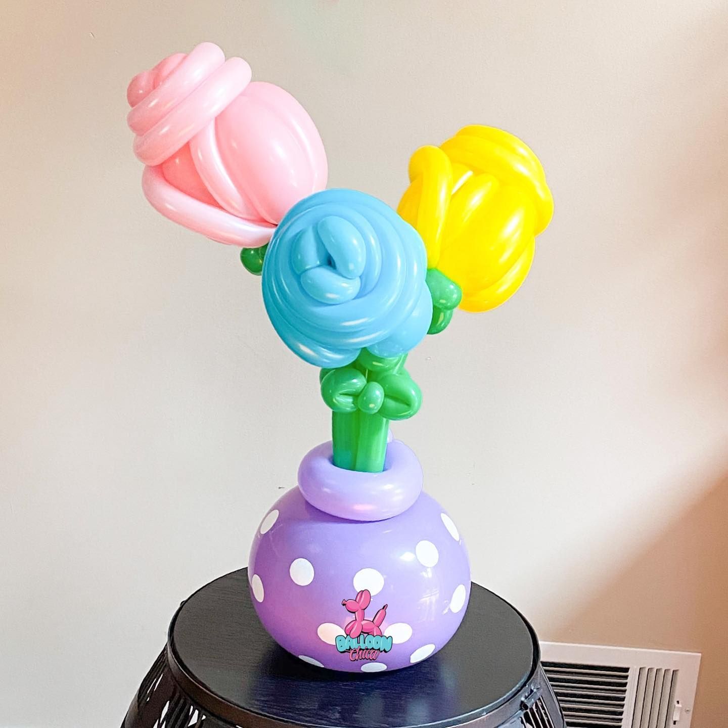 a vase filled with balloon flowers is sitting on a table