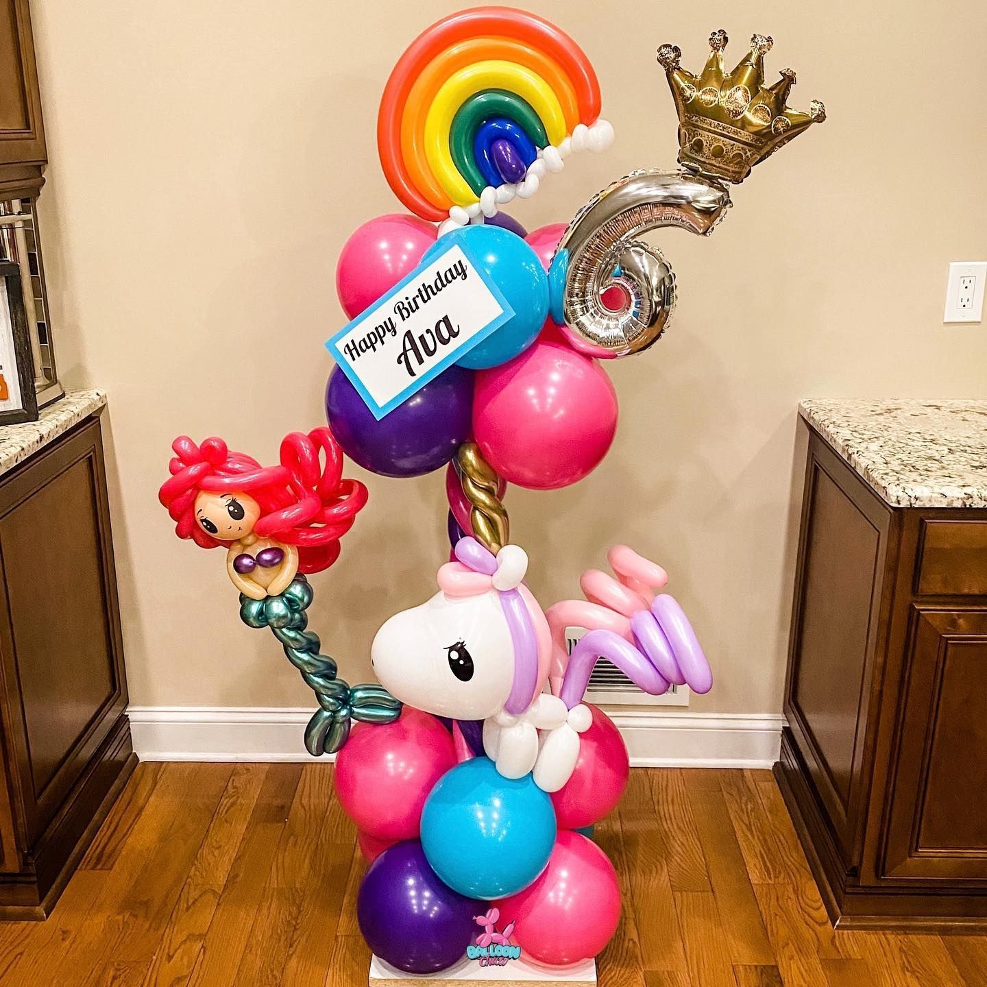 a bunch of balloons shaped like a unicorn and a mermaid are sitting on a table