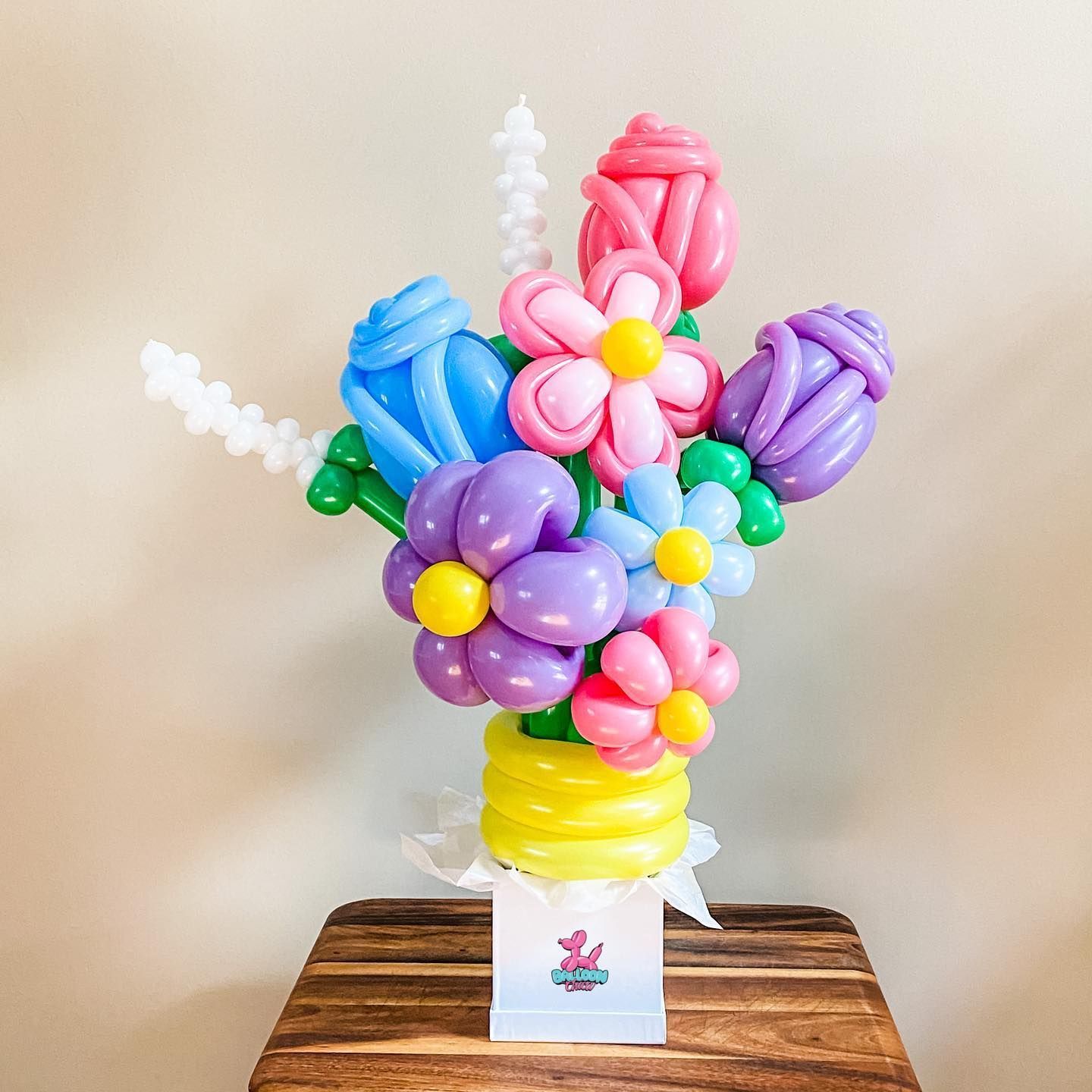 a bouquet of balloon flowers in a vase on a wooden table