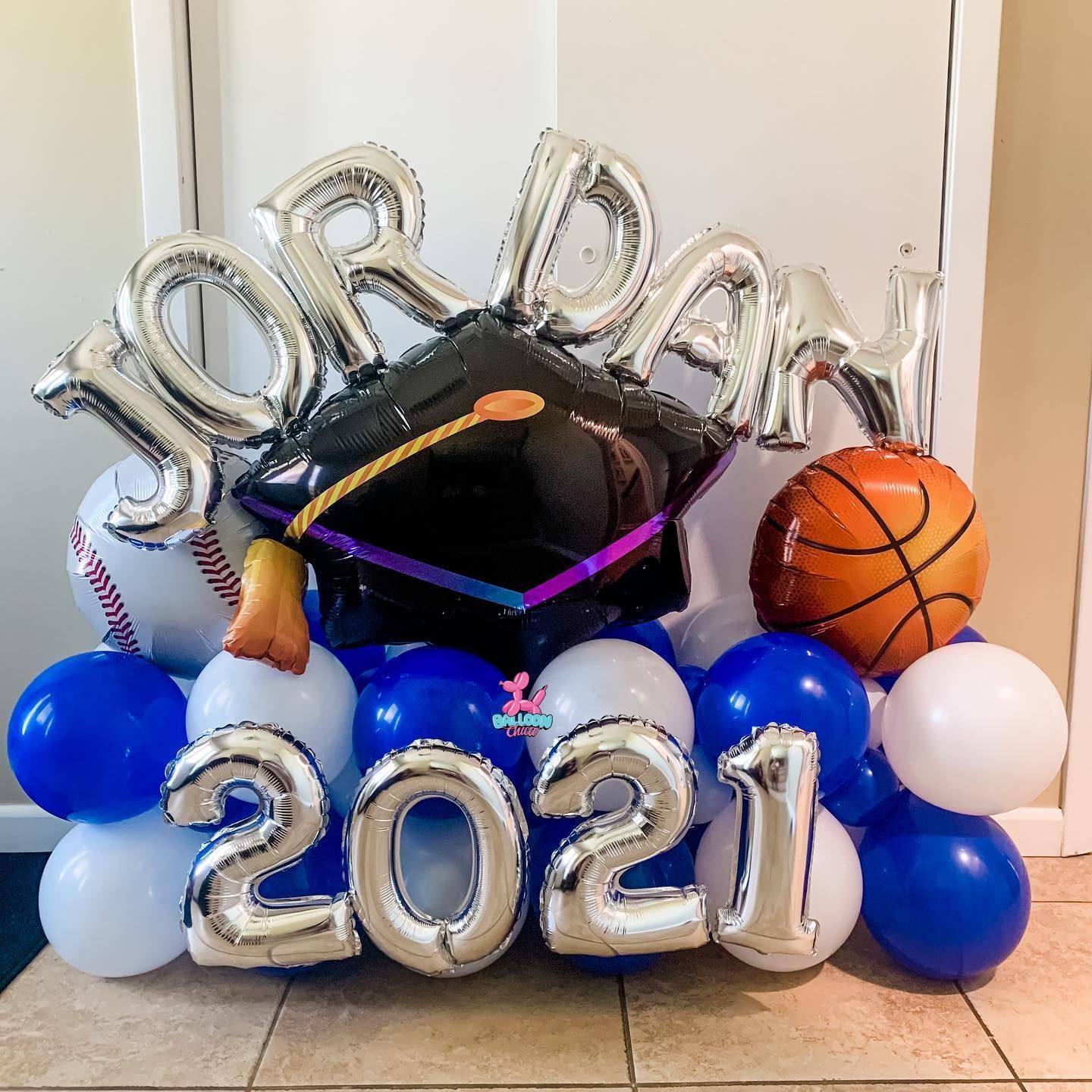 a bunch of balloons with a graduation cap on top of them