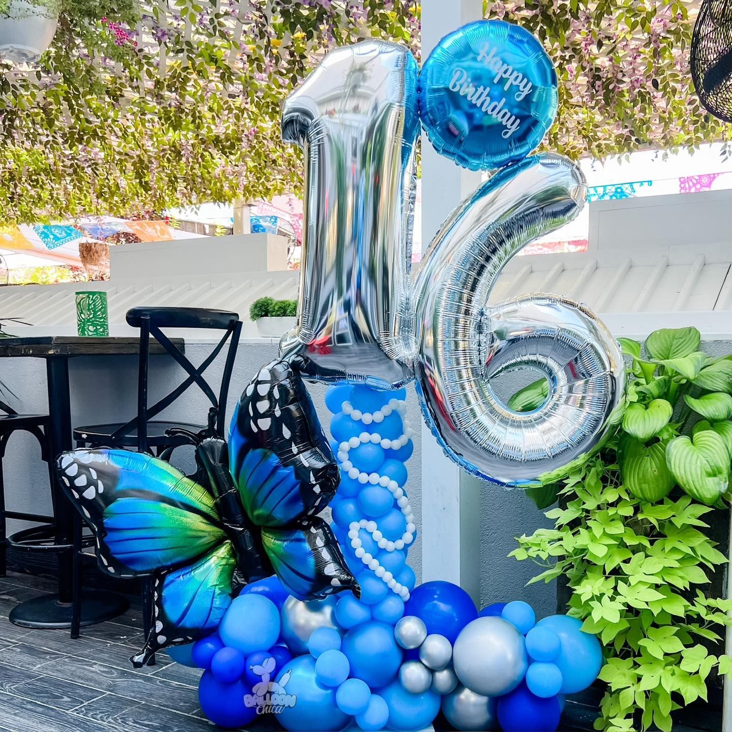 a bunch of blue and silver balloons are sitting on a table