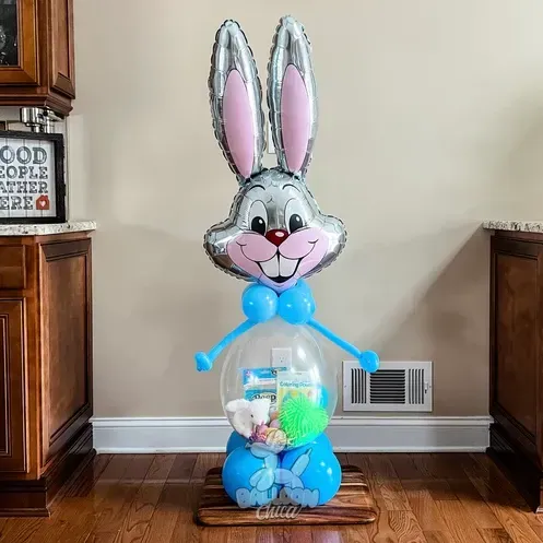 a bunny shaped balloon is sitting on a wooden stand
