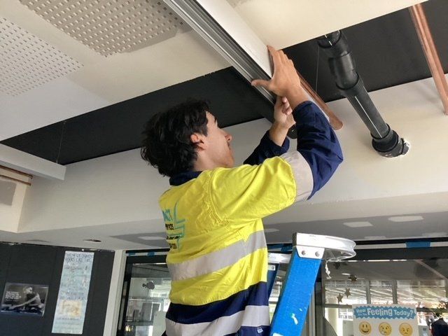 an electrician repairing an electrical tube