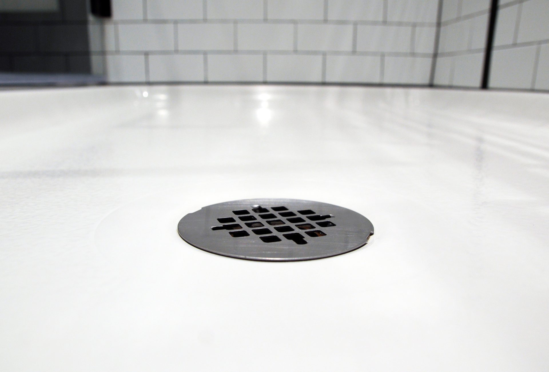 A close up of a shower drain in a bathroom.