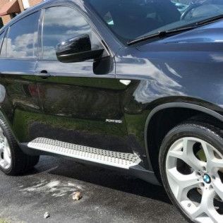 A black bmw x6 is parked in a driveway.