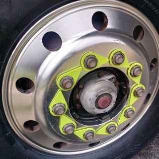 A close up of a truck wheel with a yellow sticker on it.