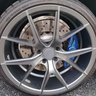 A close up of a car wheel with a brake and a tire.