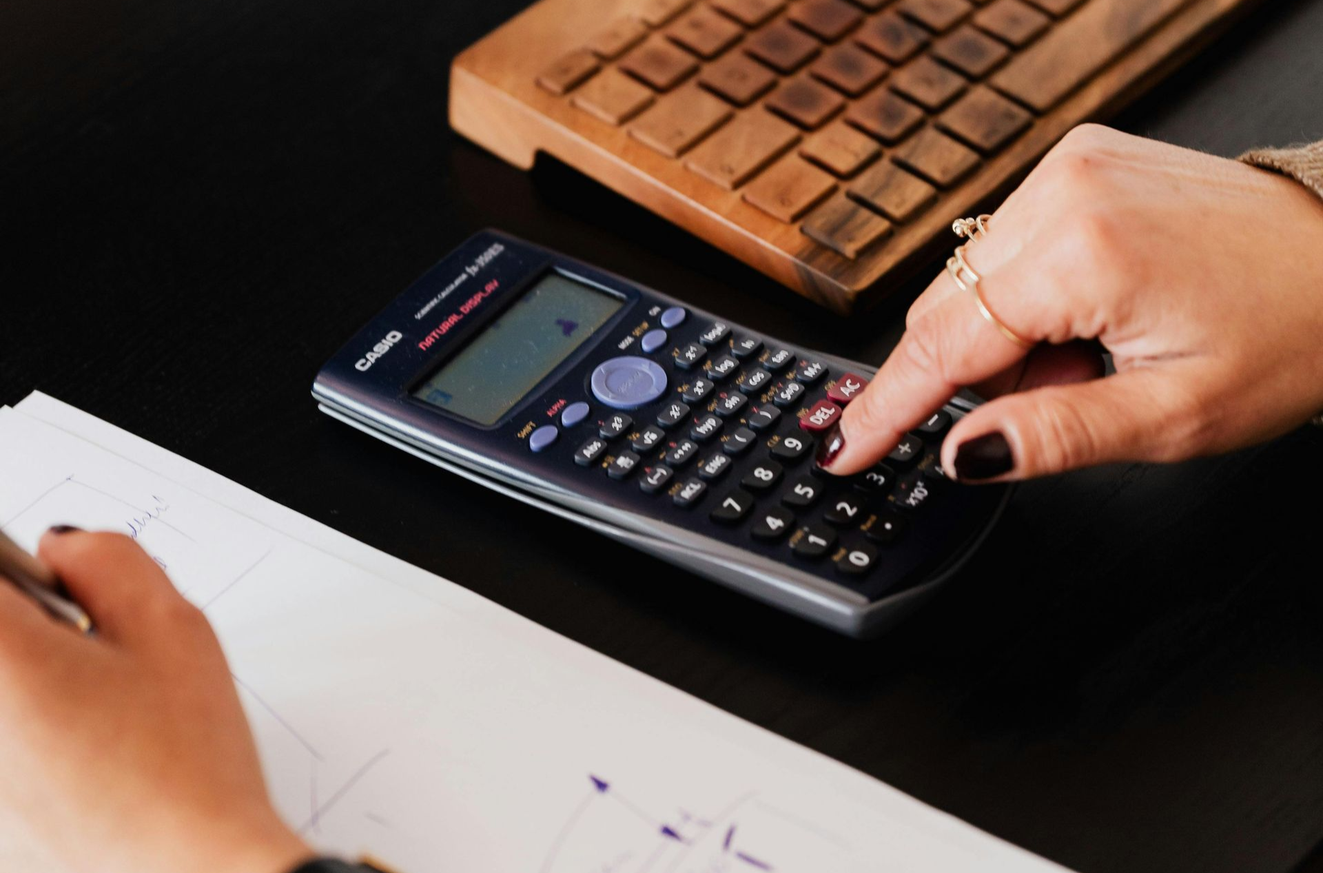 Hands typing on a silver laptop.
