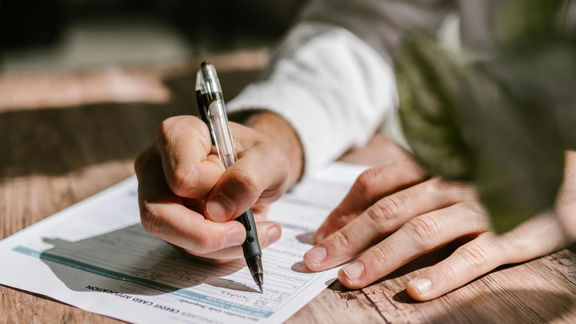 Notebook, glasses, calculator, and business plan on a wooden desk.