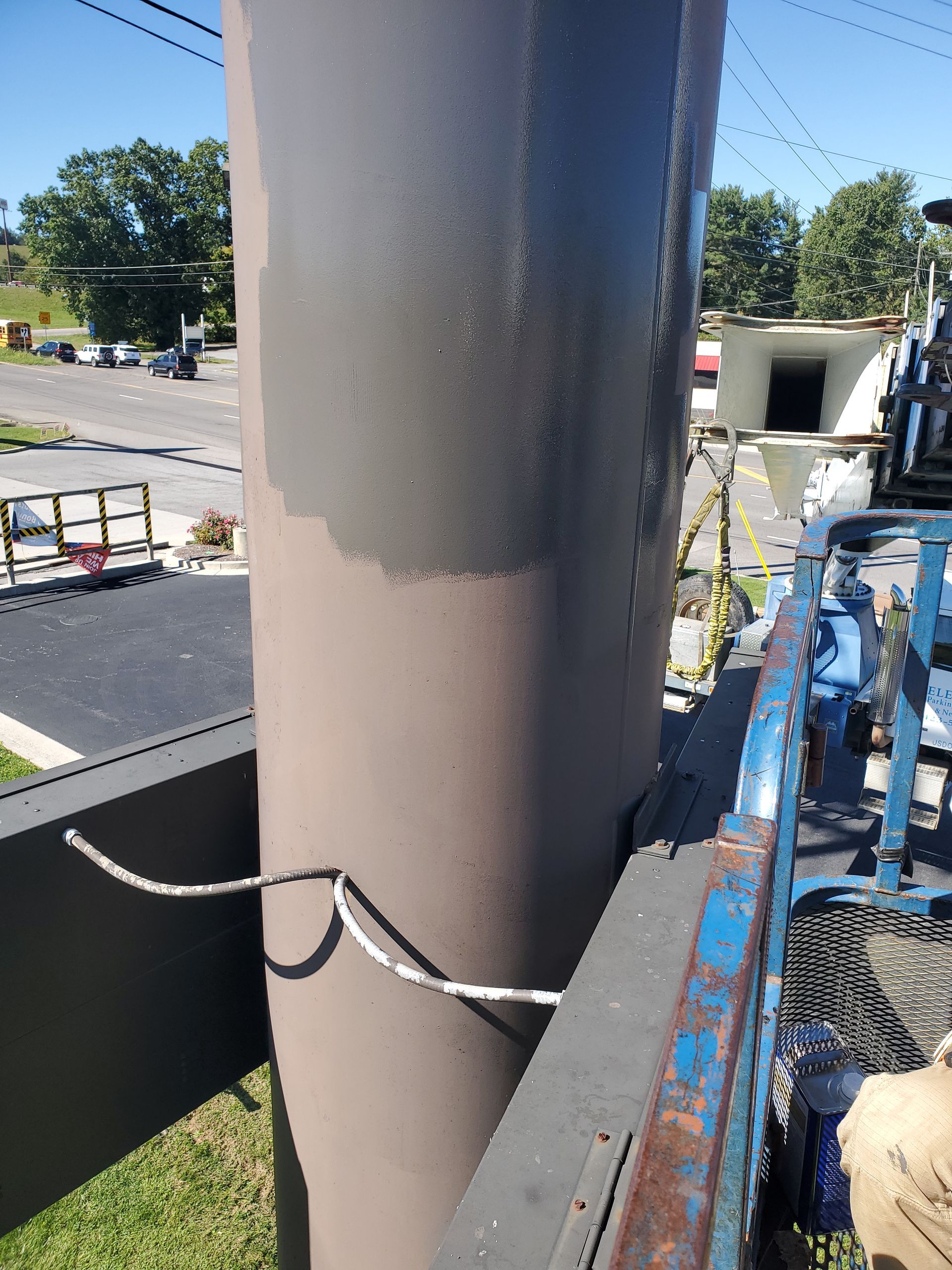 A large pipe is being painted on the side of a building