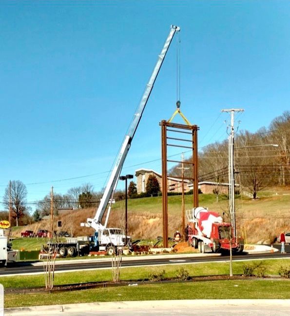 A crane is lifting a wooden structure in a parking lot