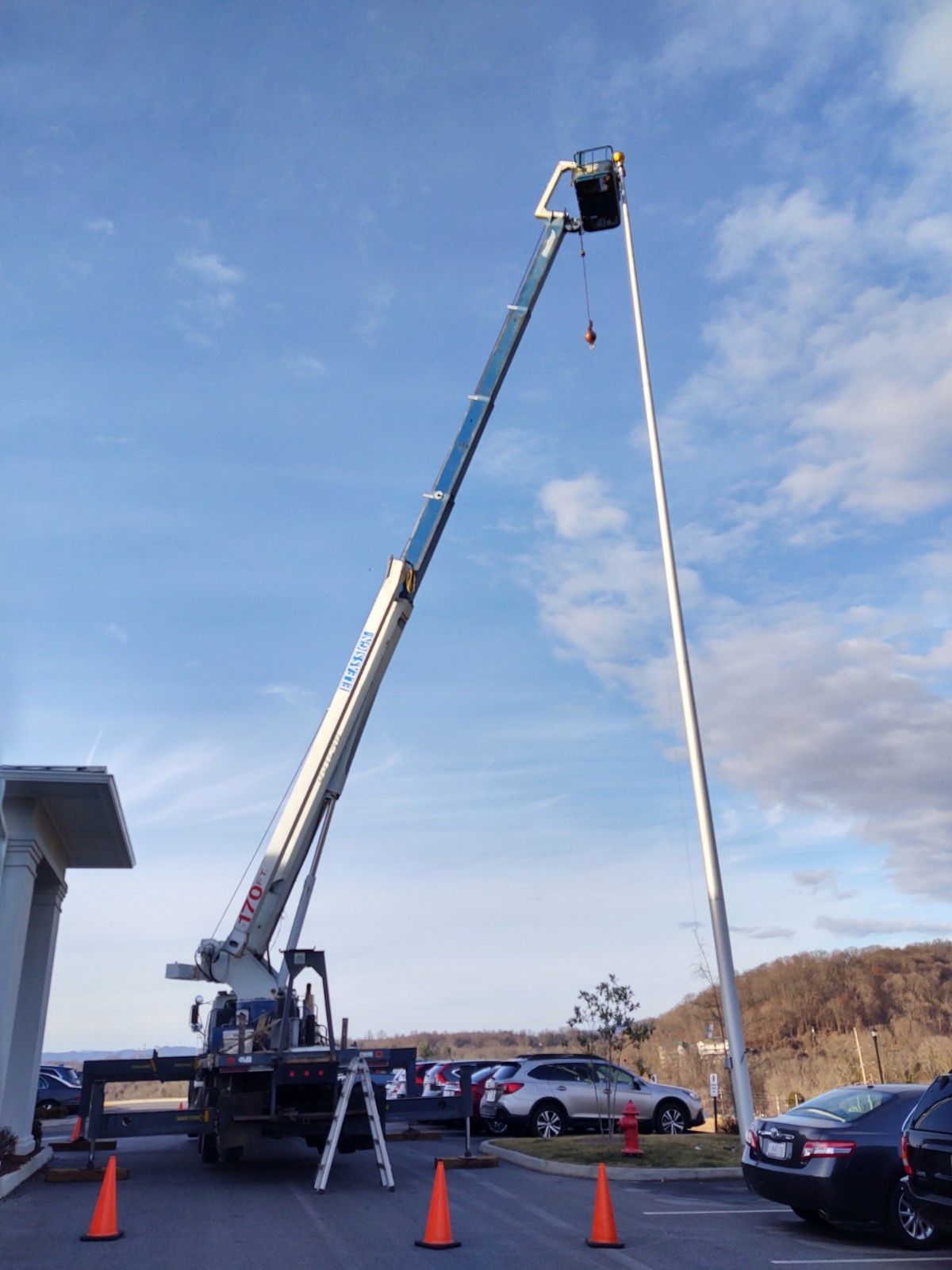 A large crane is lifting a sign into the air.