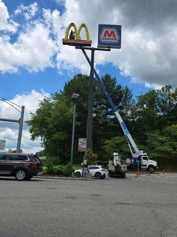 A mcdonald 's sign is being installed in a parking lot