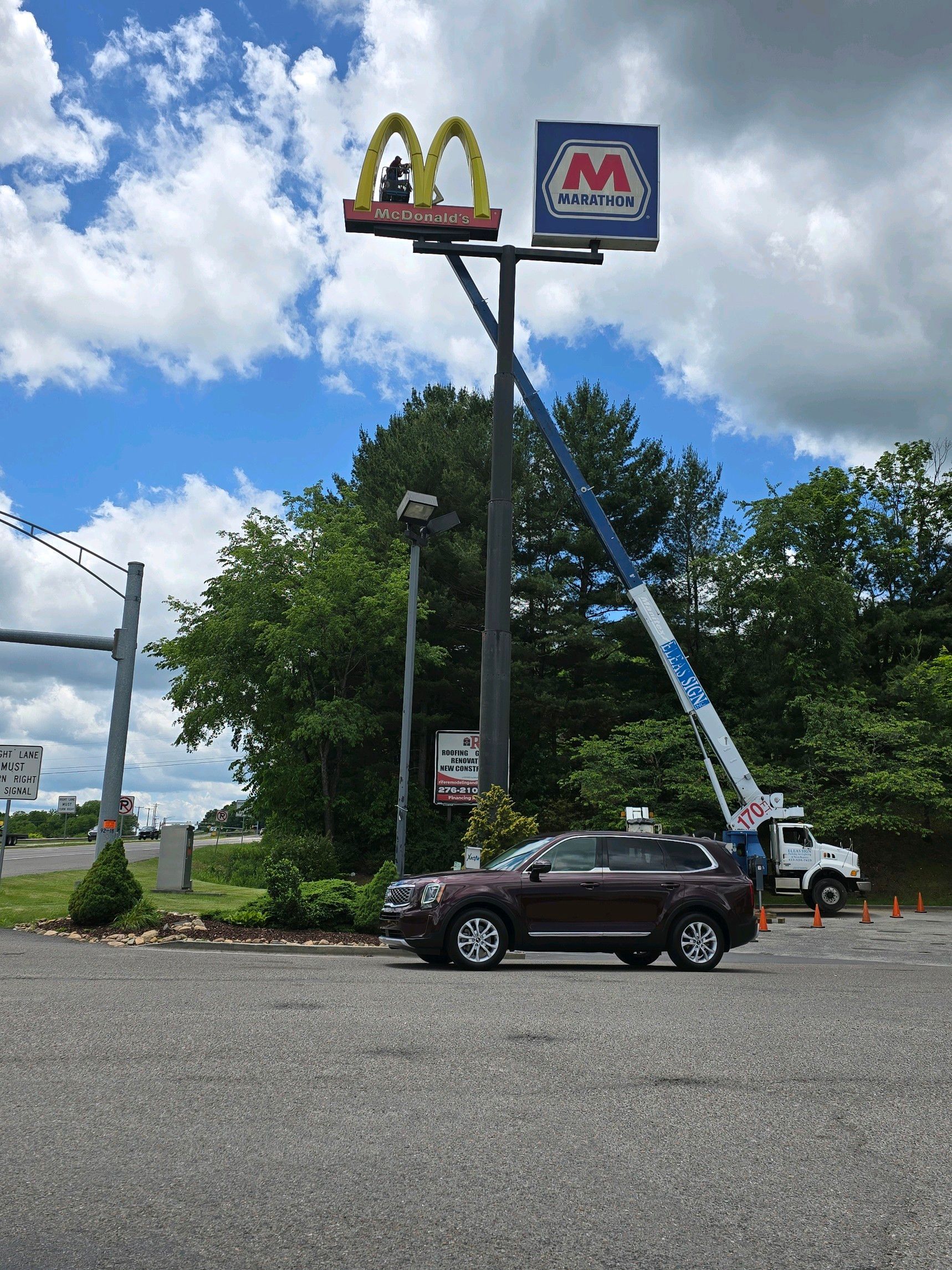 A mcdonald 's sign is being removed by a crane