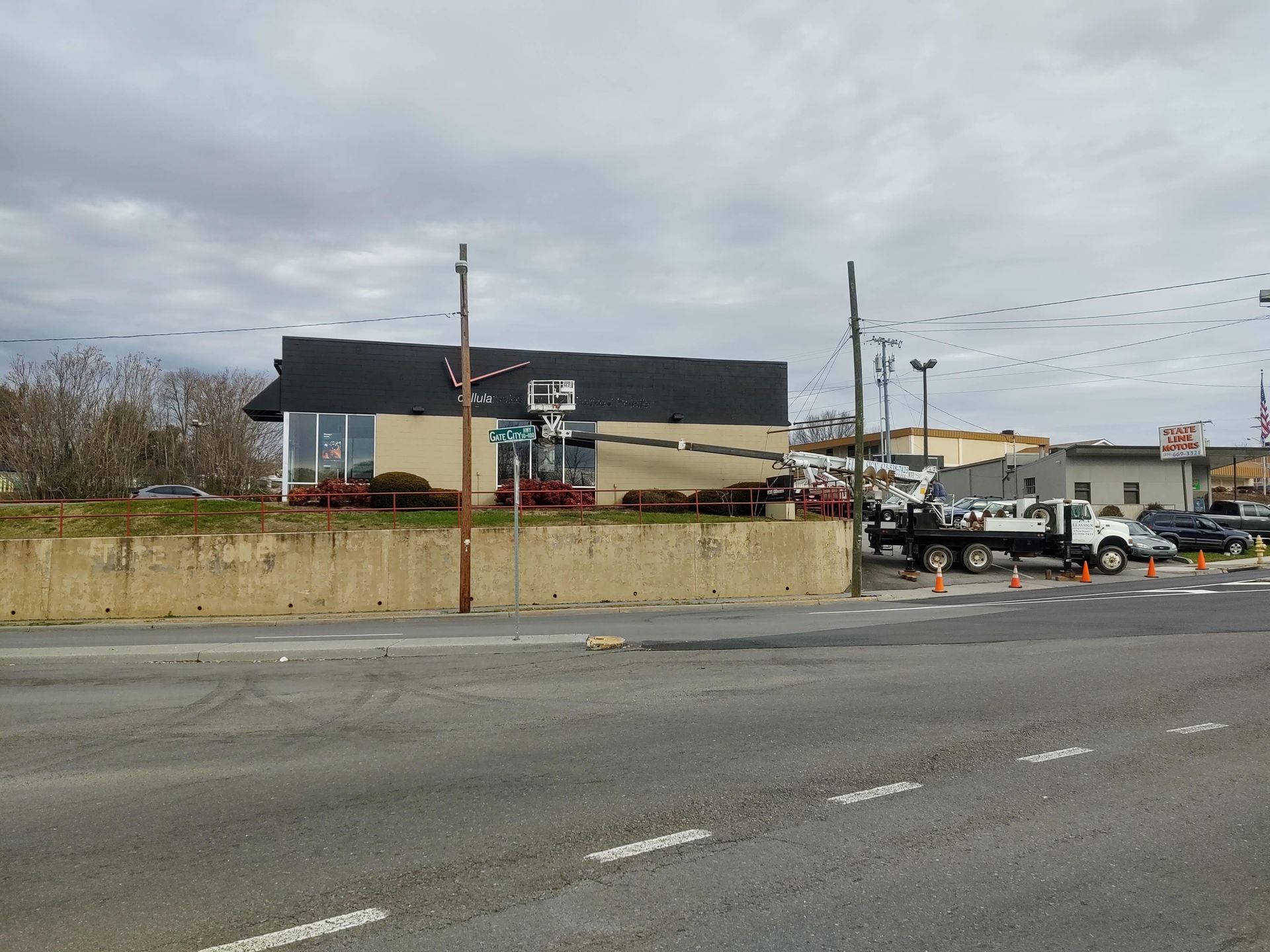 A truck is parked on the side of the road in front of a building