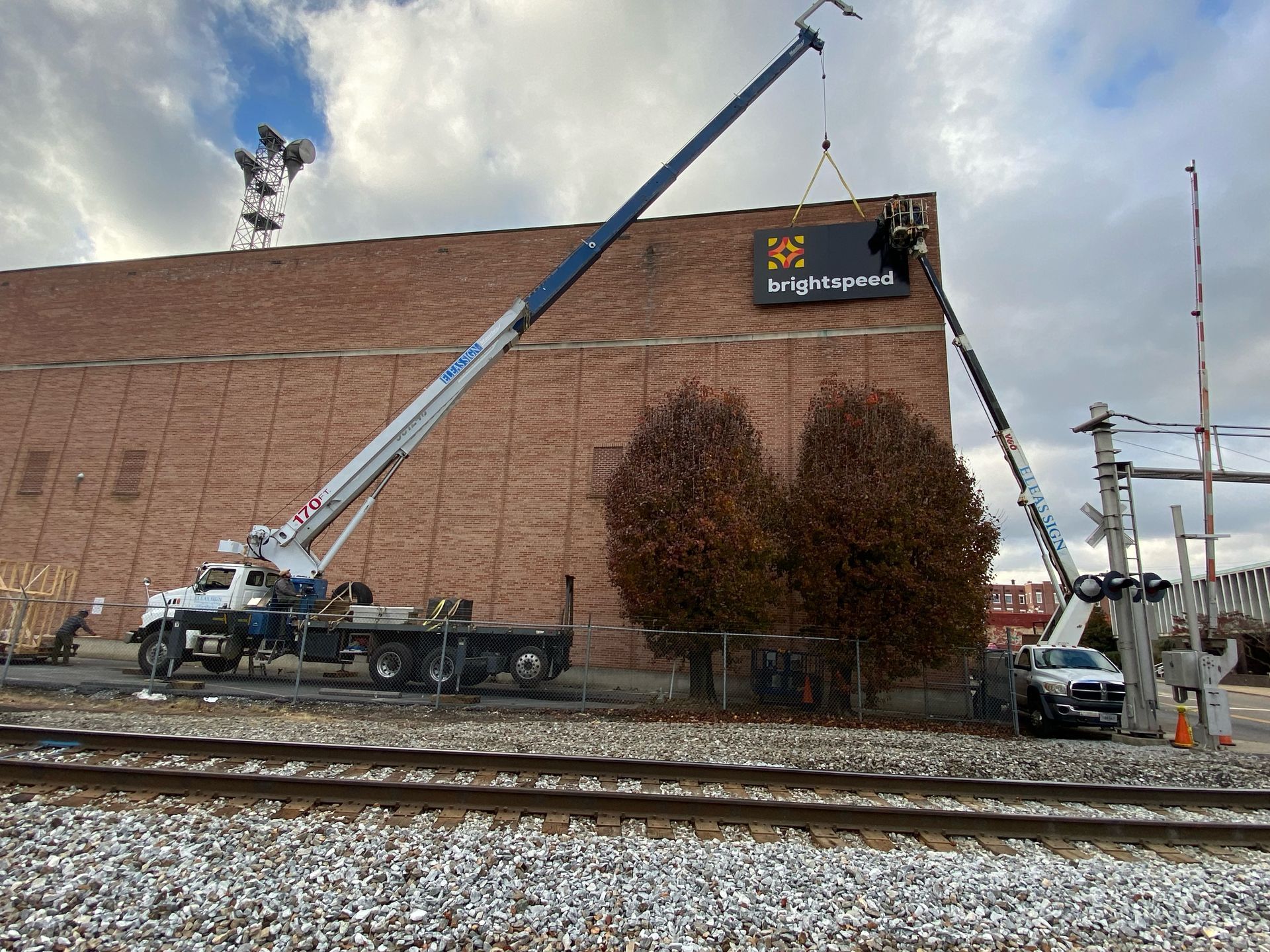 A crane is lifting a sign on the side of a building.