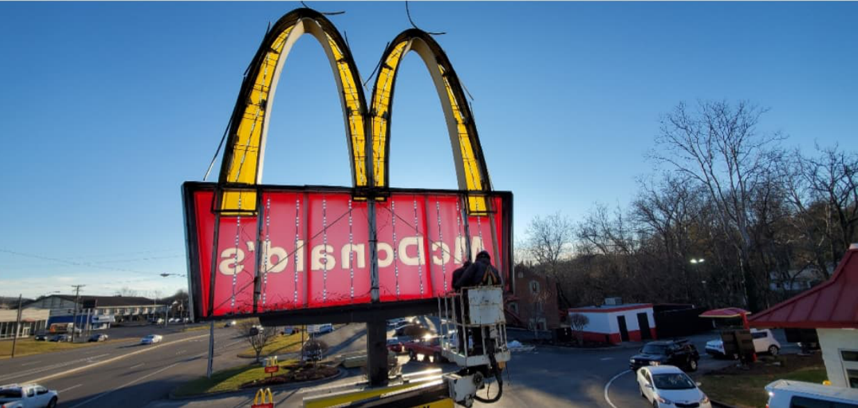 A red mcdonald 's sign is hanging over a street