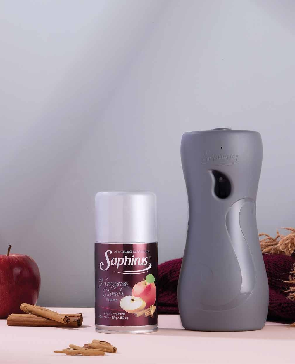 Ambientador y bote con aroma a manzana y canela sobre superficie rosa.