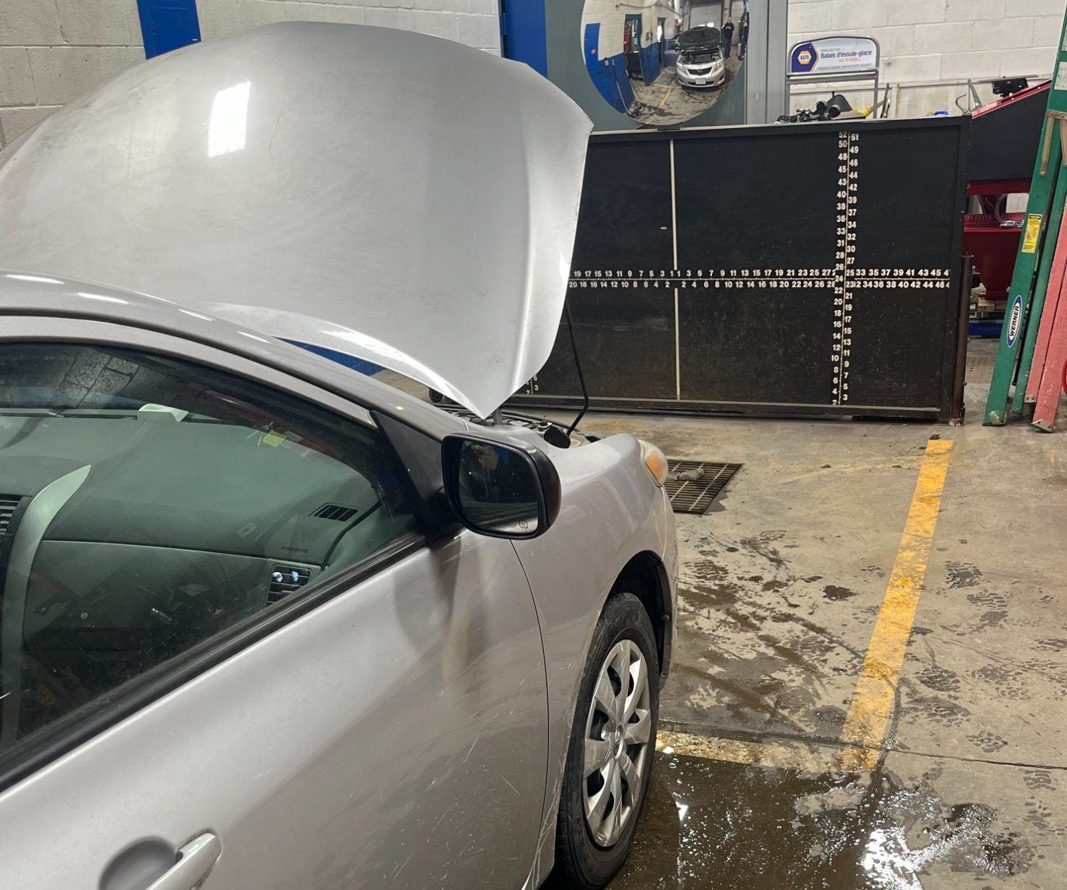 Silver car with hood open in an auto repair shop | Diamond Automotive