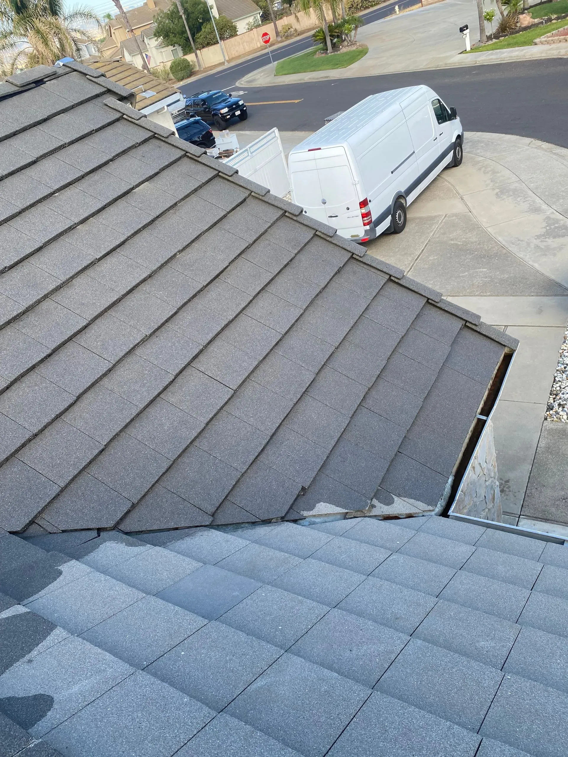 A white van is parked on the roof of a house.