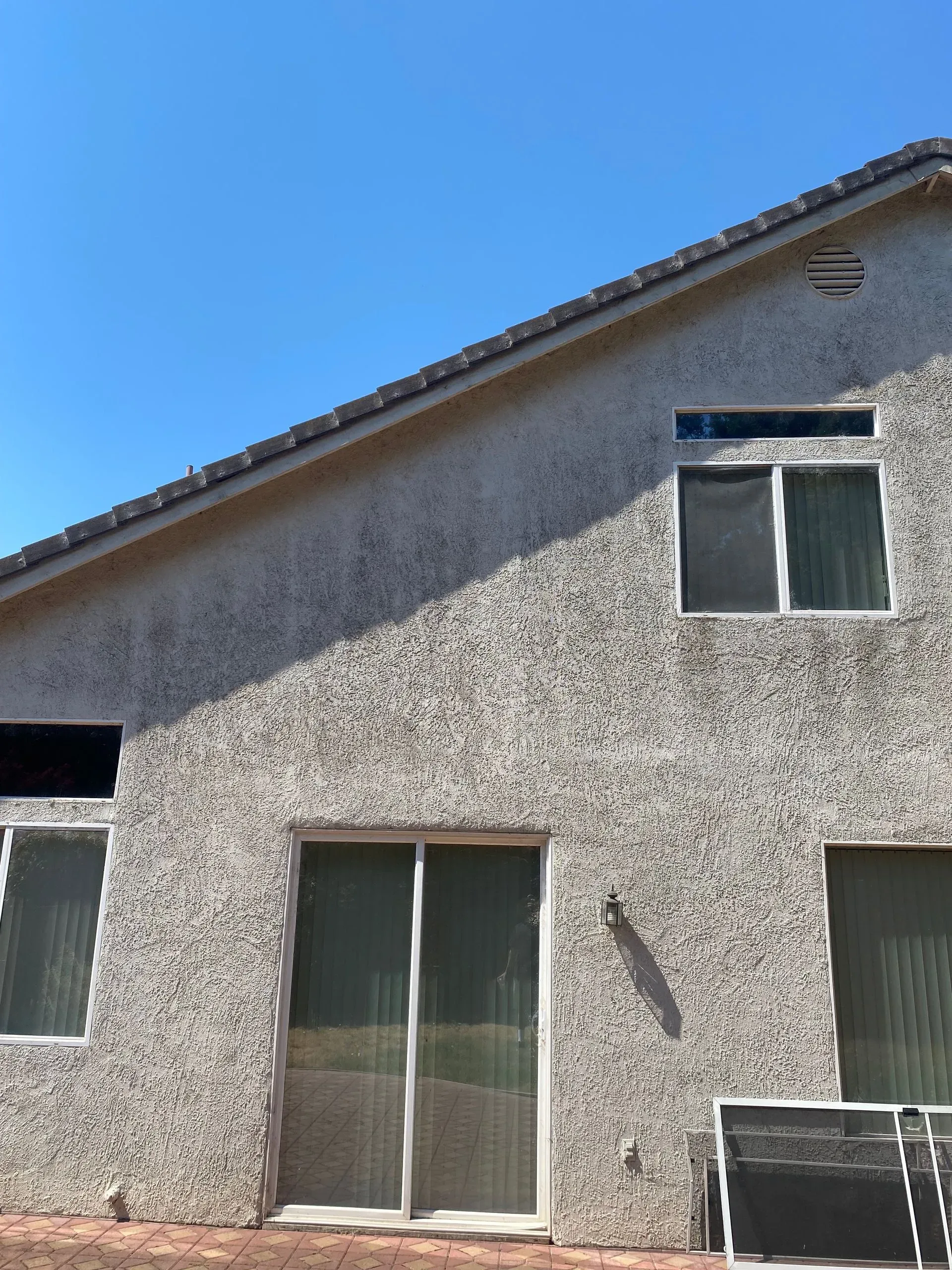 The back of a house with a blue sky in the background