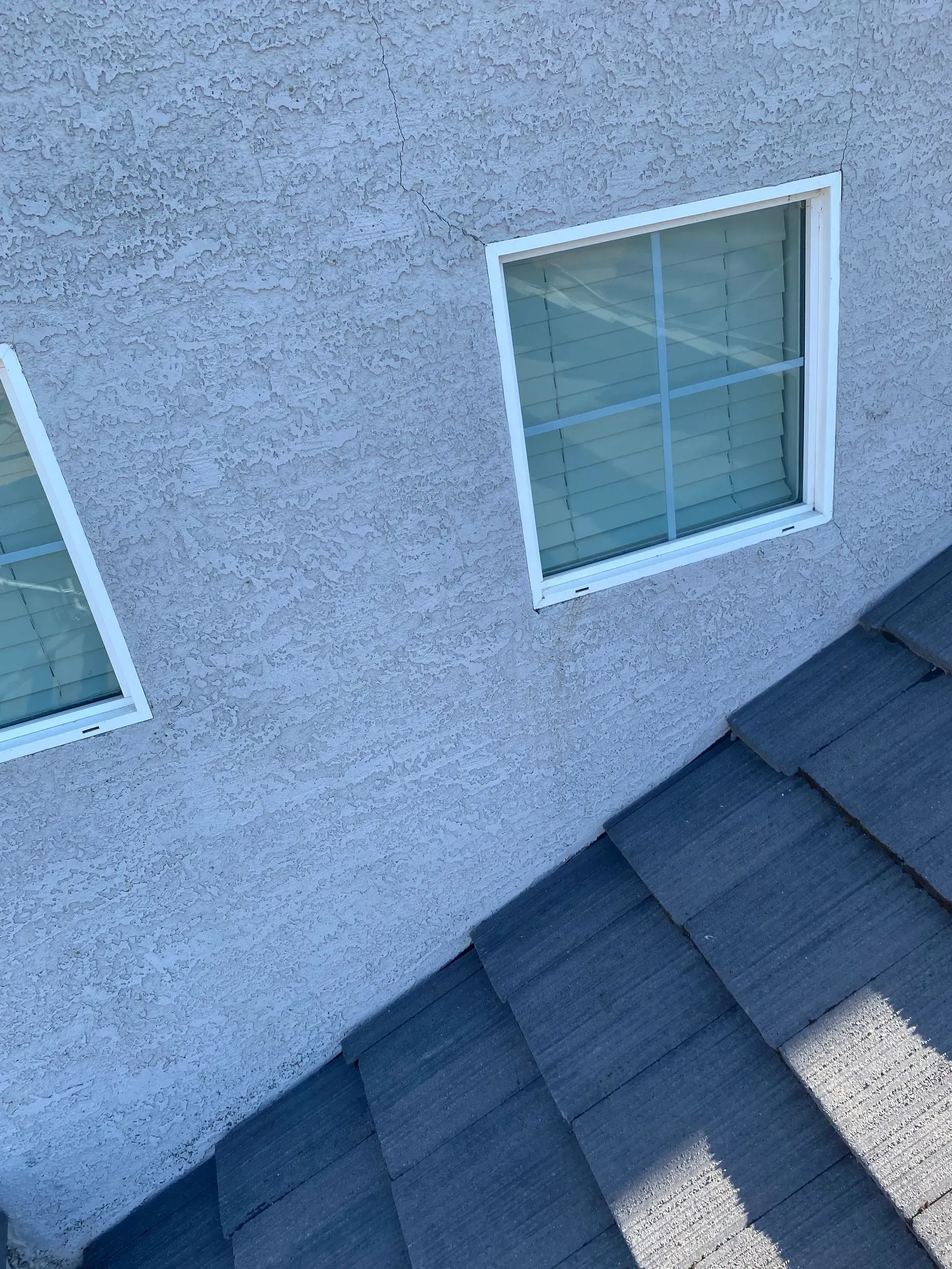 A house with two square windows on the side of it.
