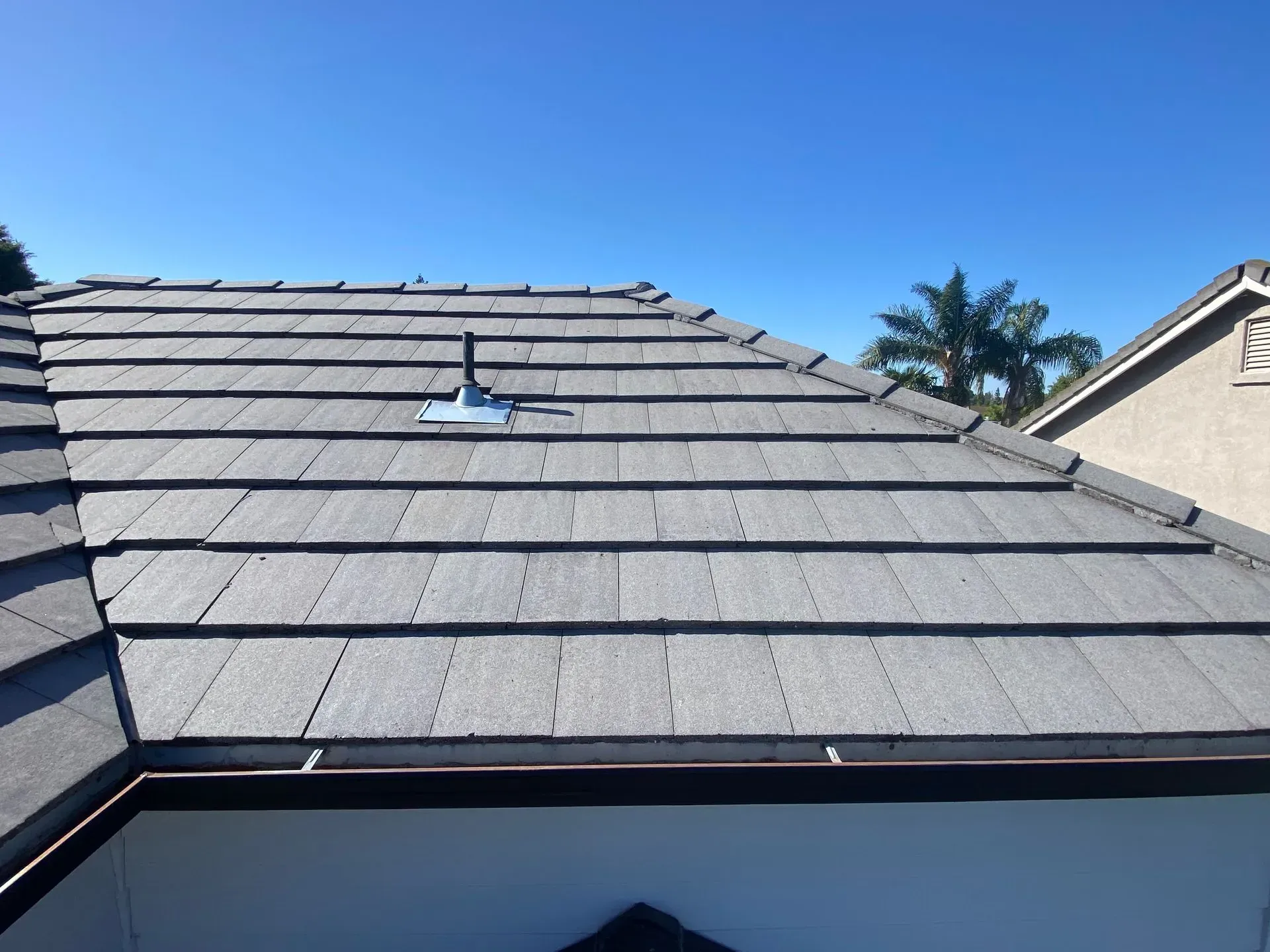 A roof of a house with a blue sky in the background
