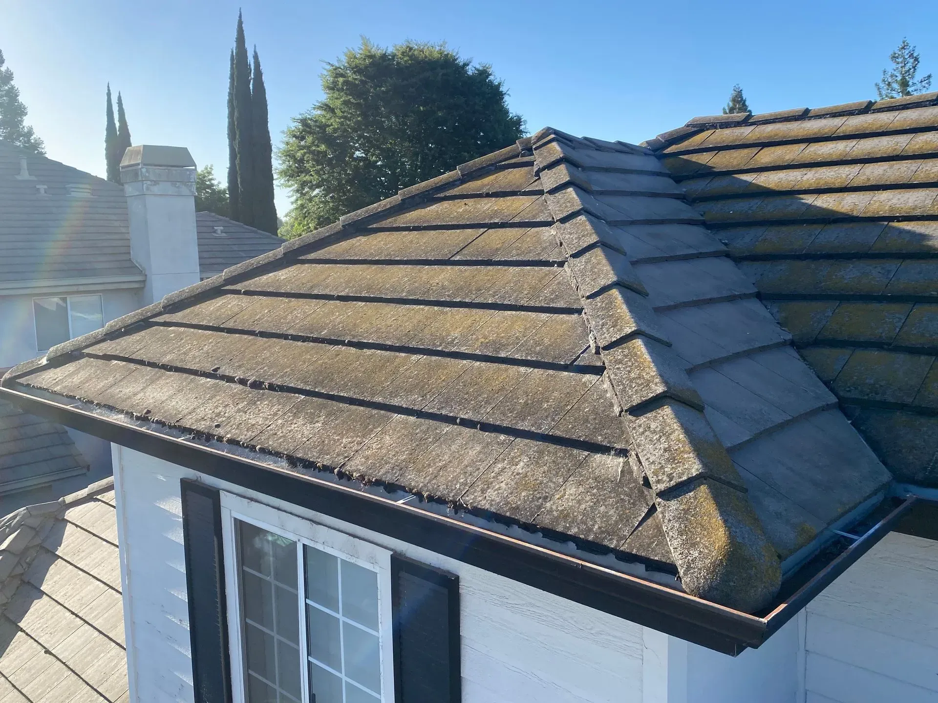 A white house with a tiled roof and a window.