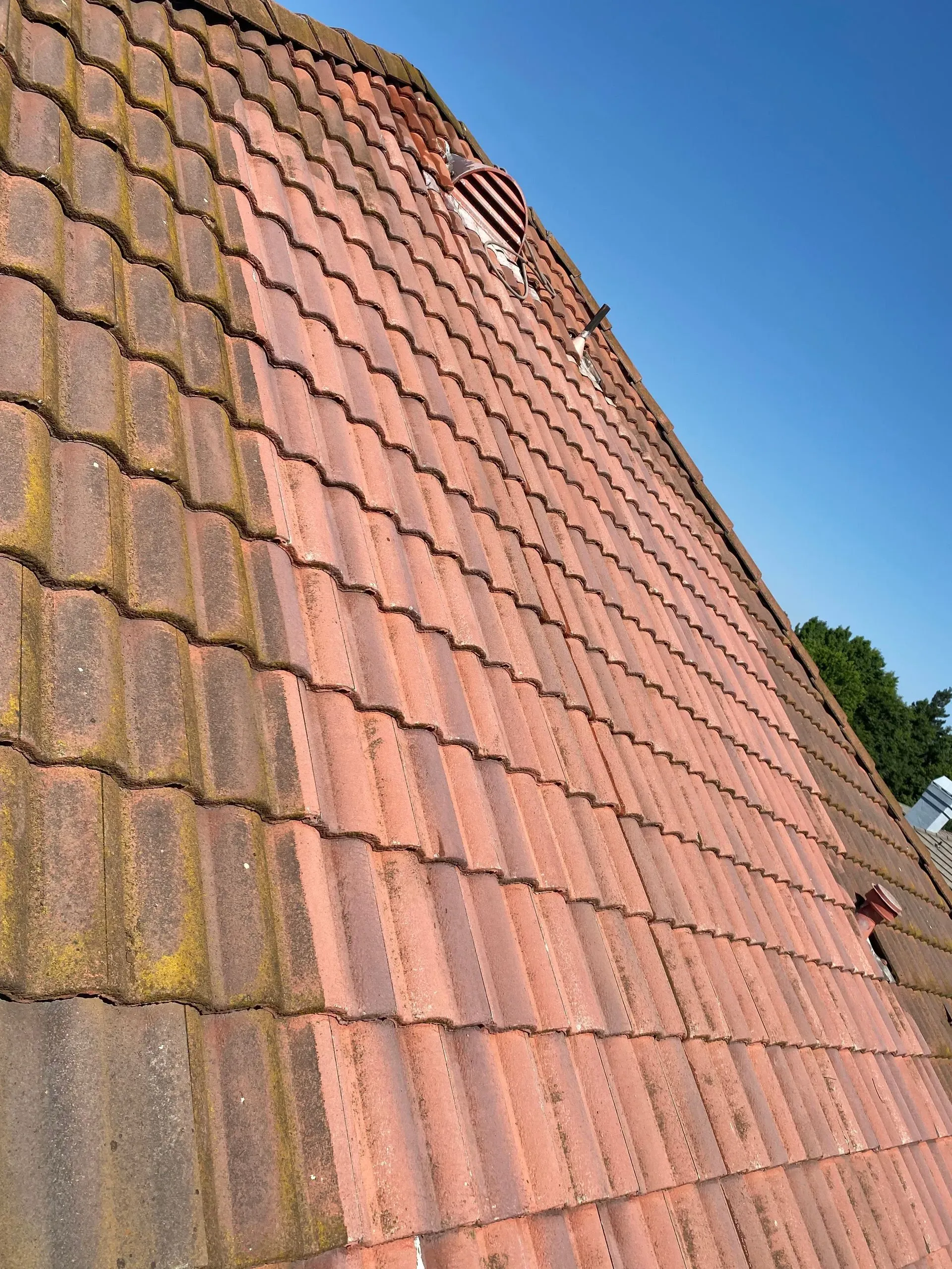 A red tiled roof with a blue sky in the background