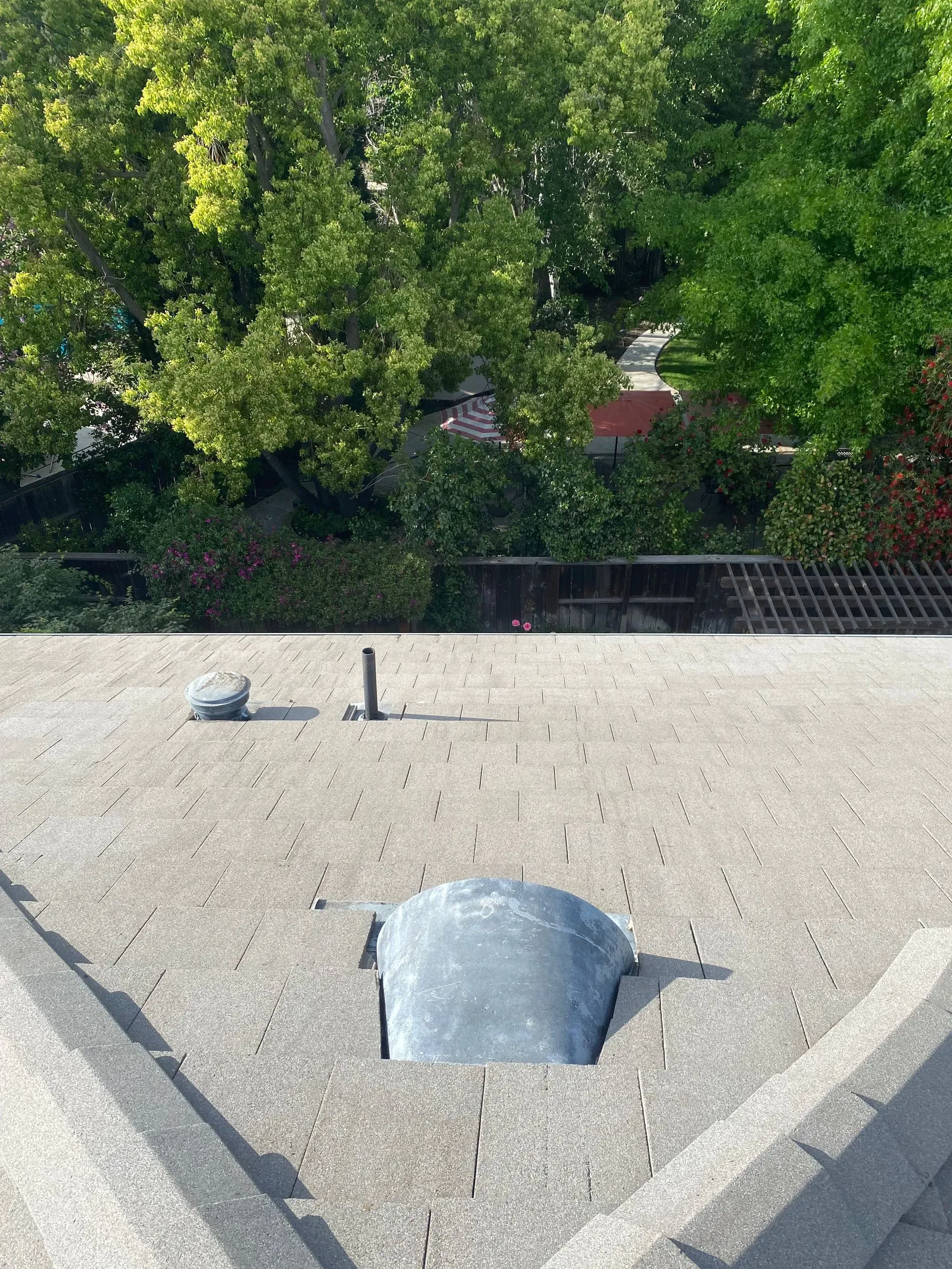 A roof with a hole in it and trees in the background.
