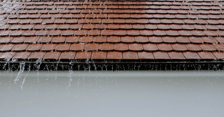 The rain is falling on the roof of a house.