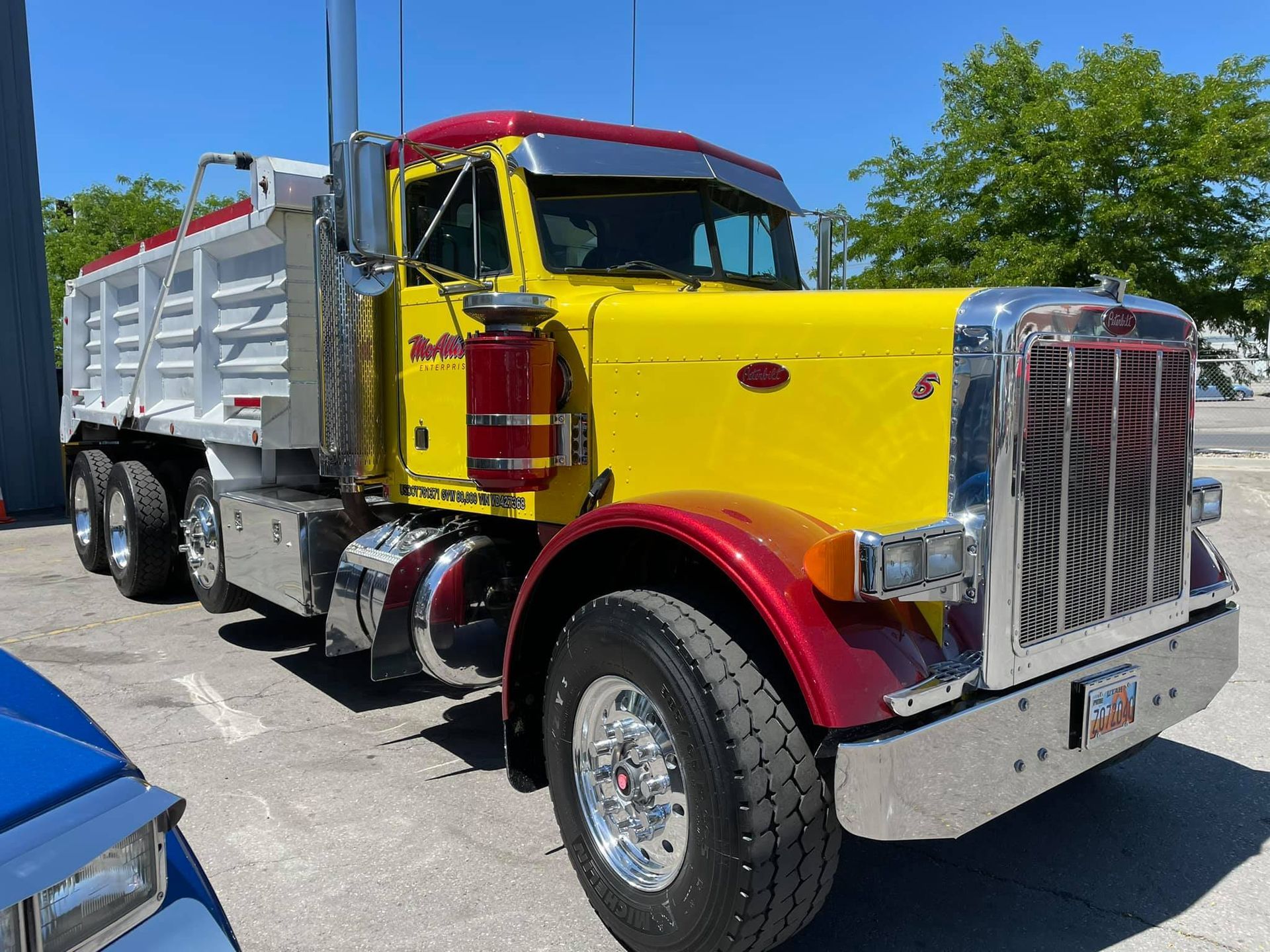 A yellow and red dump truck is parked in a parking lot.