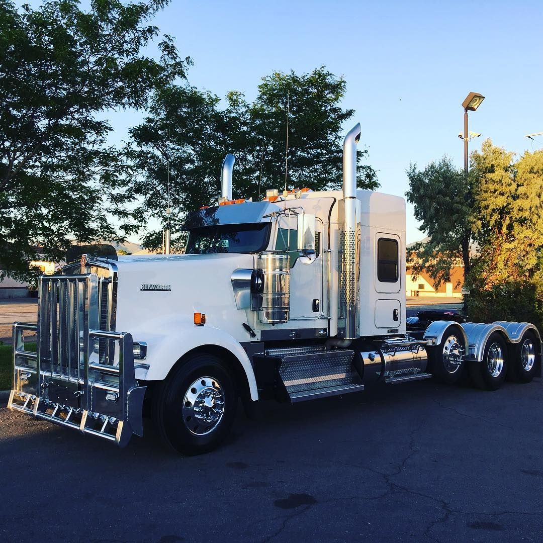 A white semi truck is parked in a parking lot.
