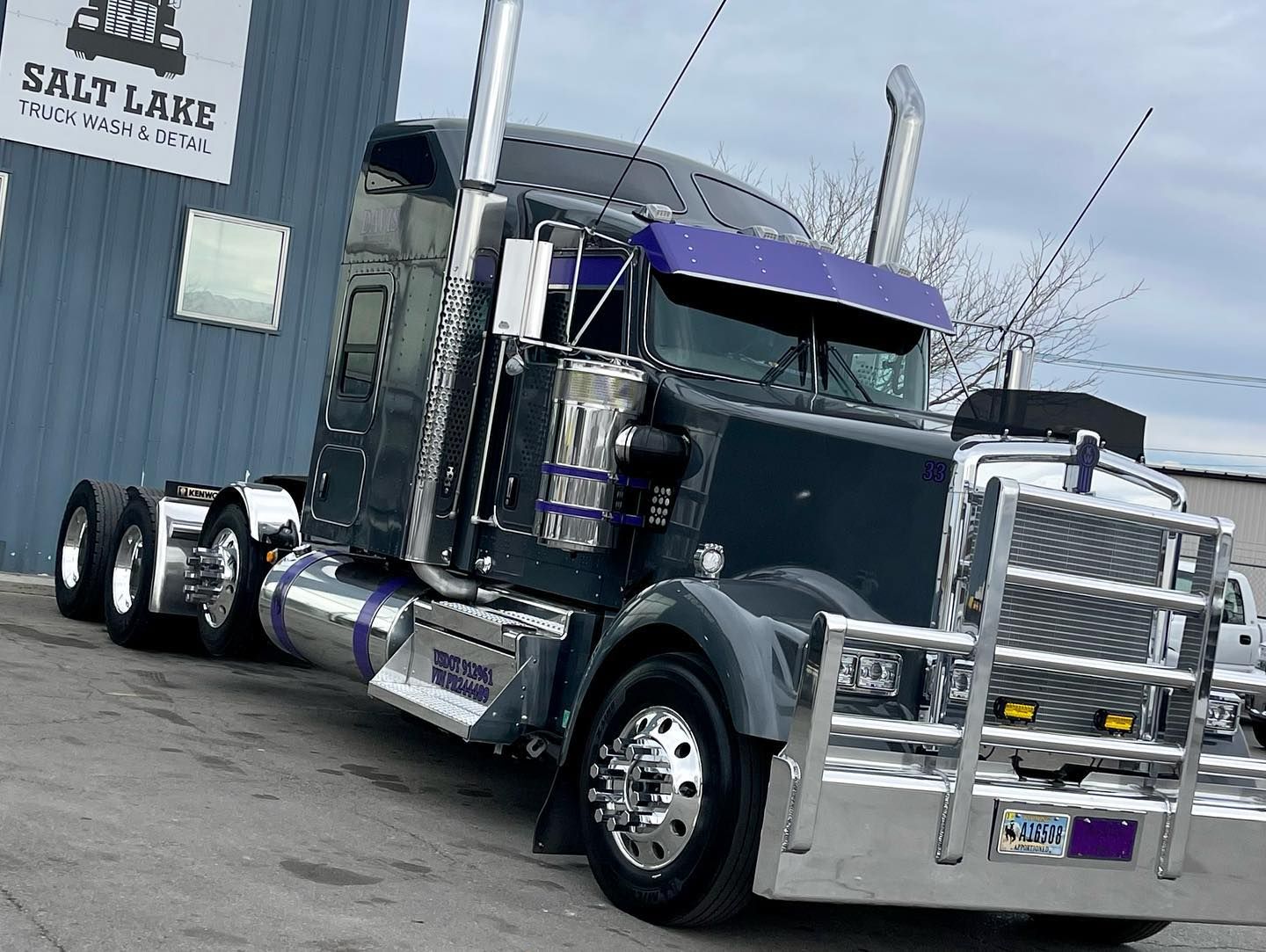 A semi truck is parked in front of a building that says salt lake.