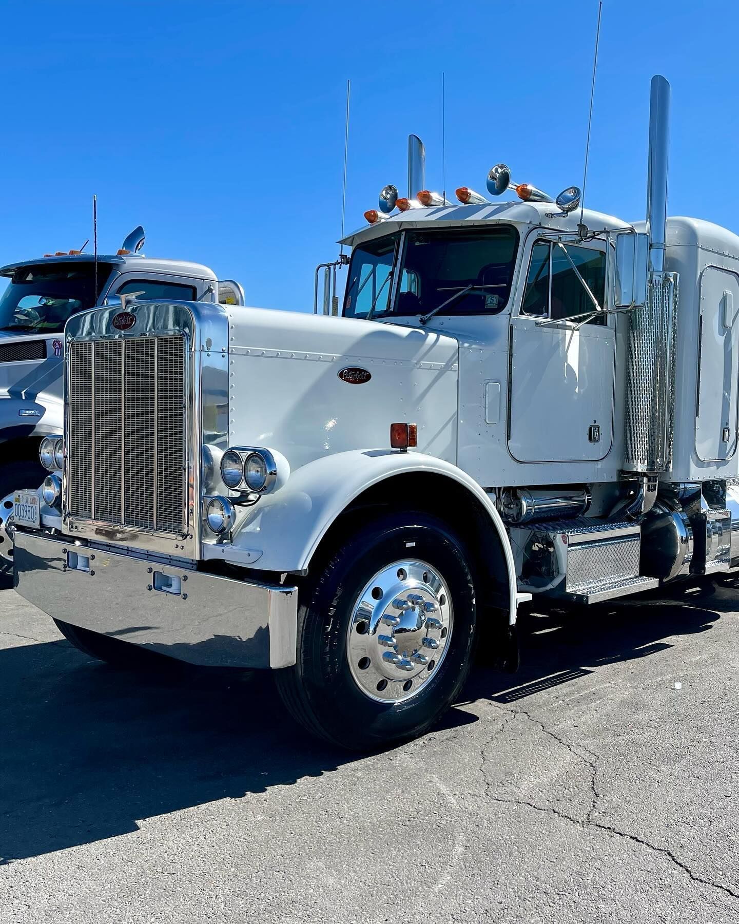 A white semi truck is parked on the side of the road