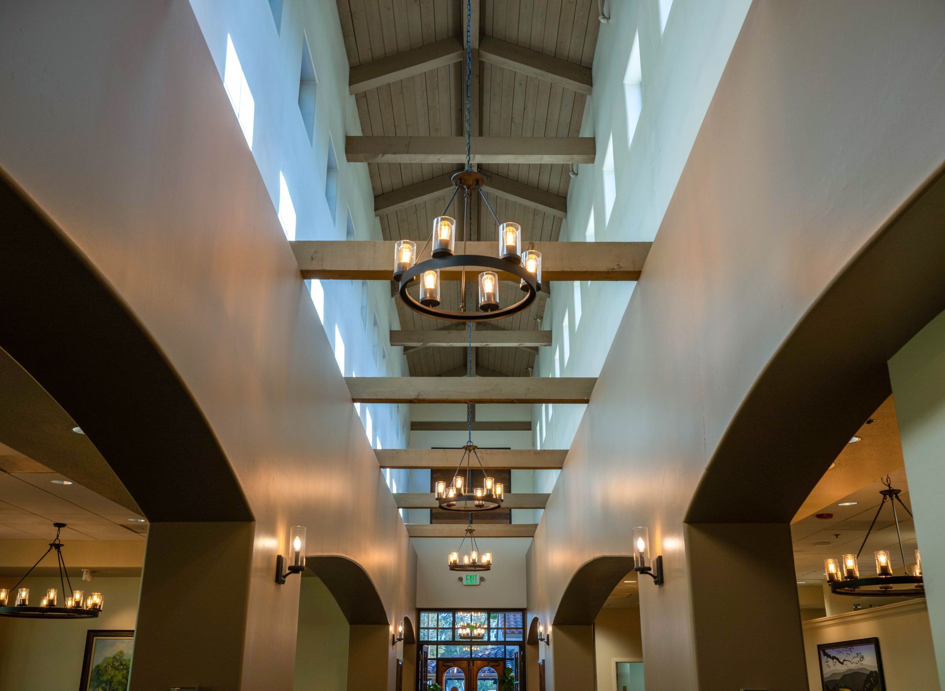 A long hallway with a chandelier hanging from the ceiling.