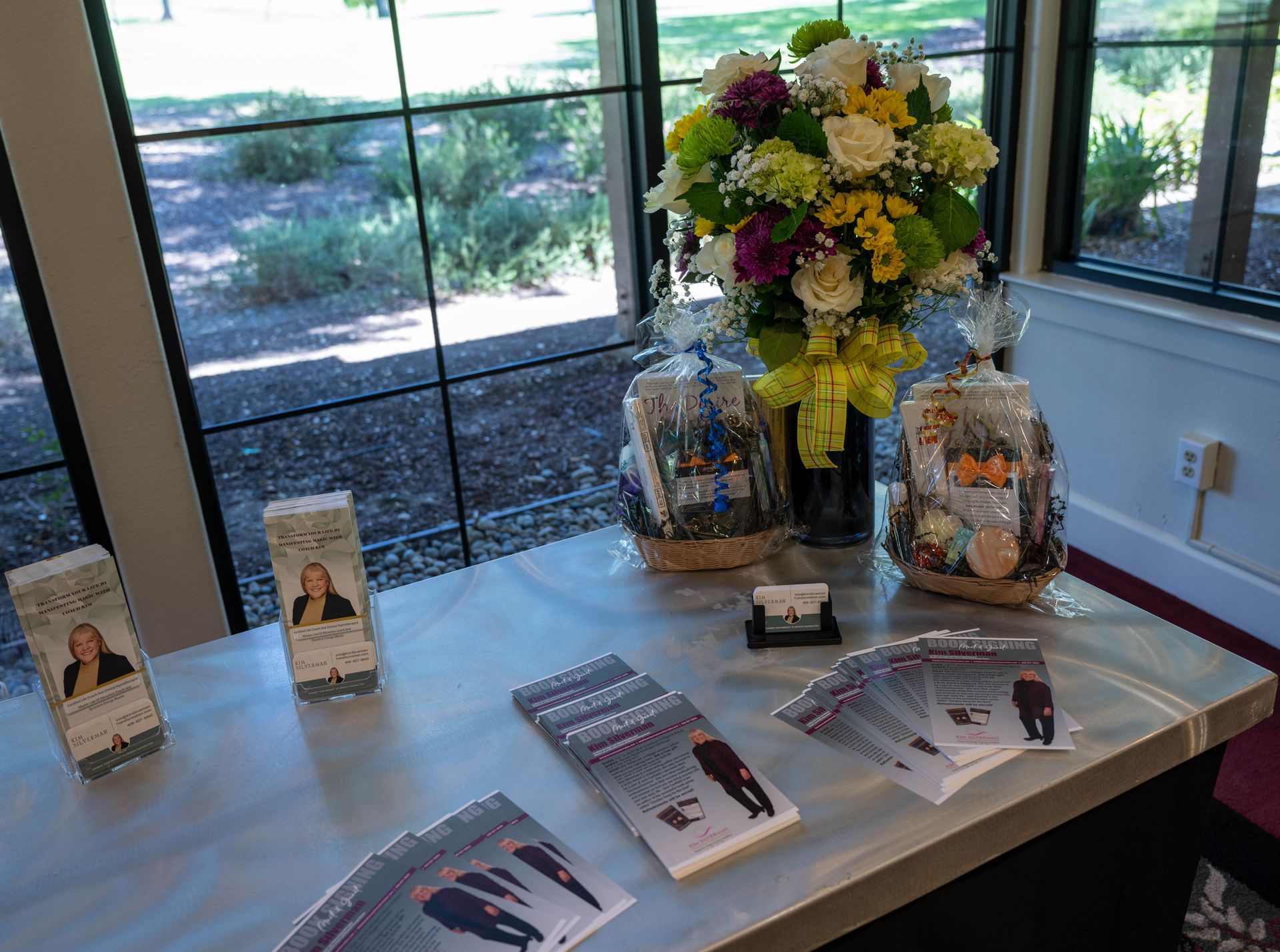 A table with a vase of flowers and brochures on it.