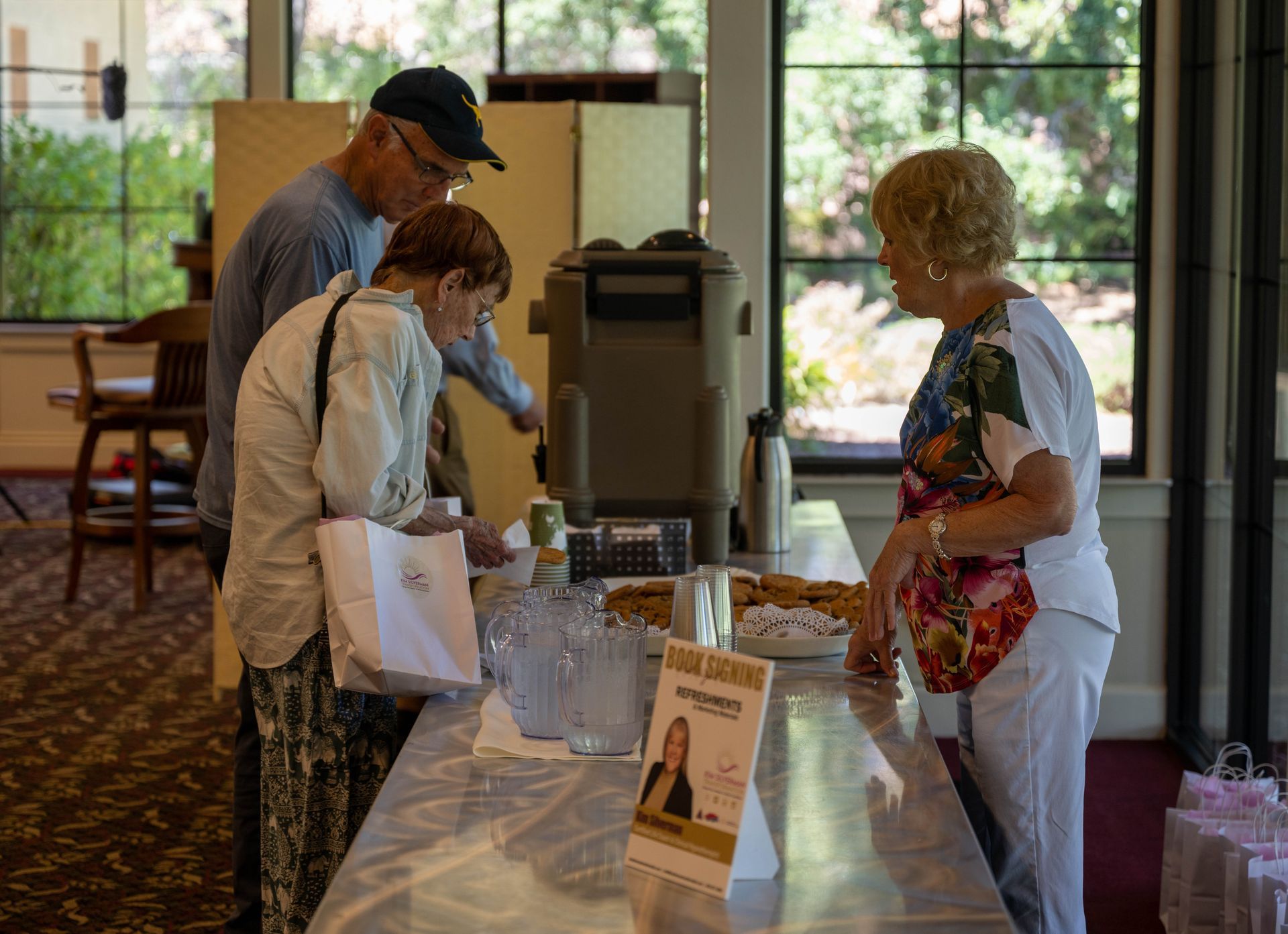 A group of people are standing around a table in a room.