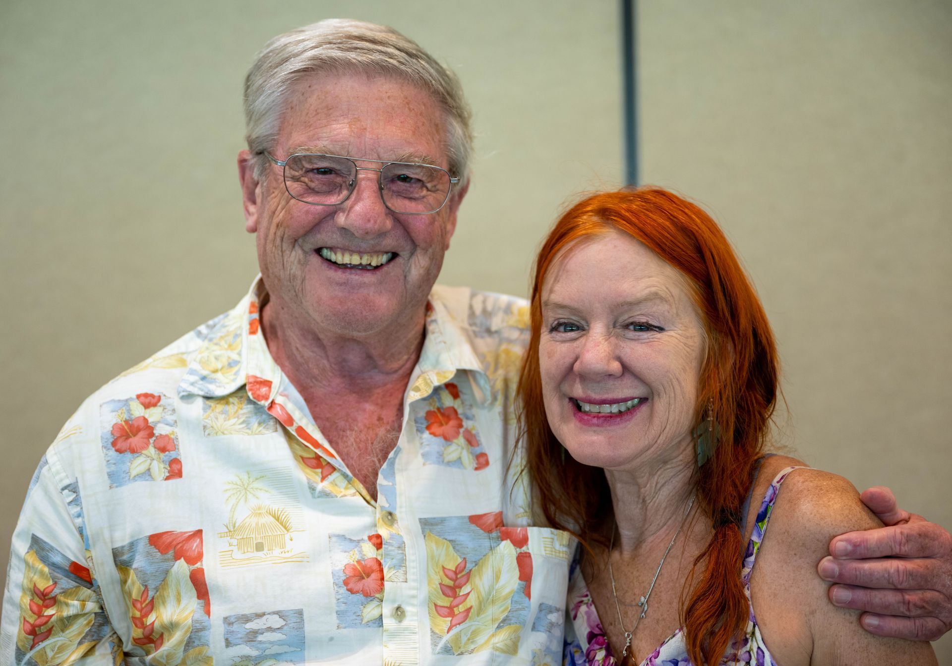 A man and a woman are posing for a picture together and smiling.