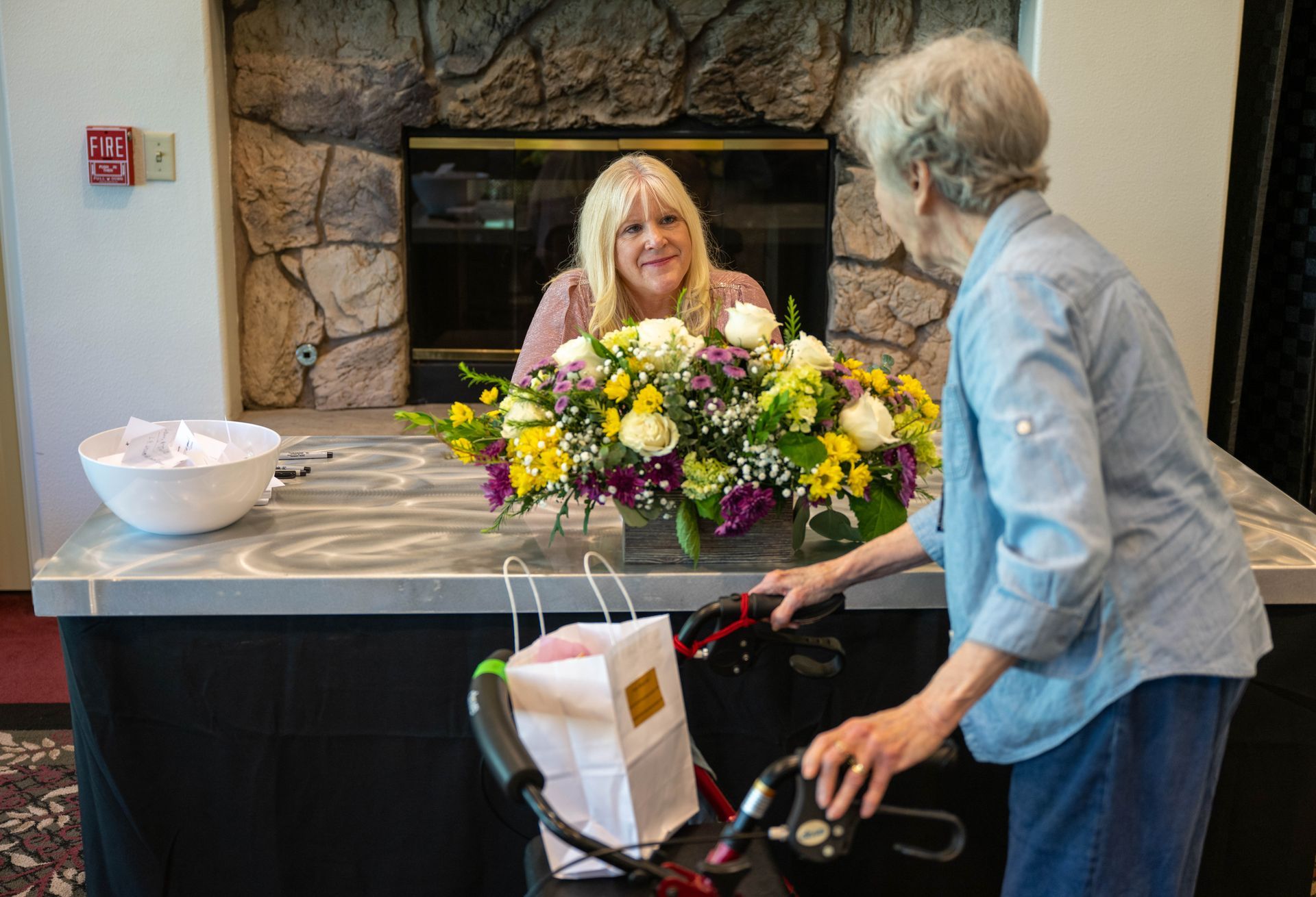 Kim Silverman with a women standing in front of a table with flowers on it.