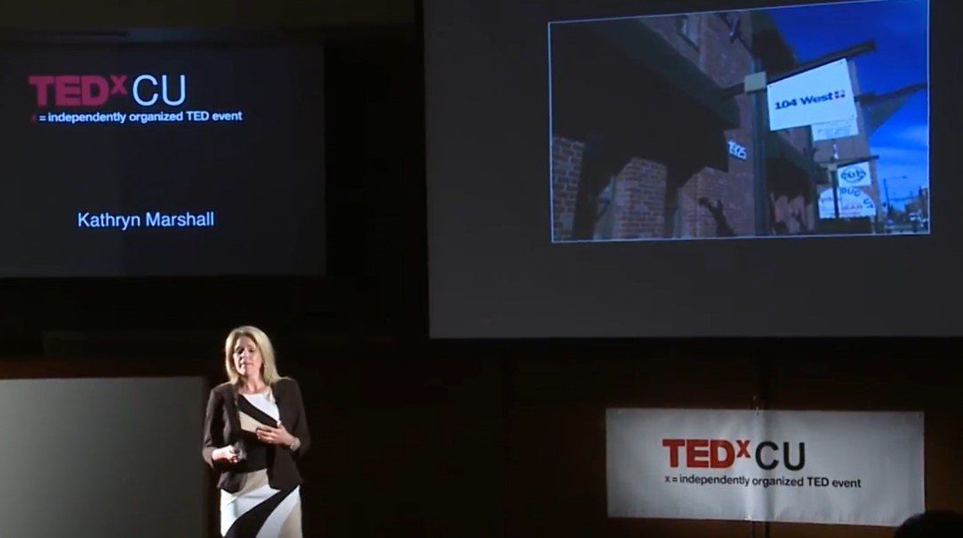 A woman is giving a presentation at ted cu