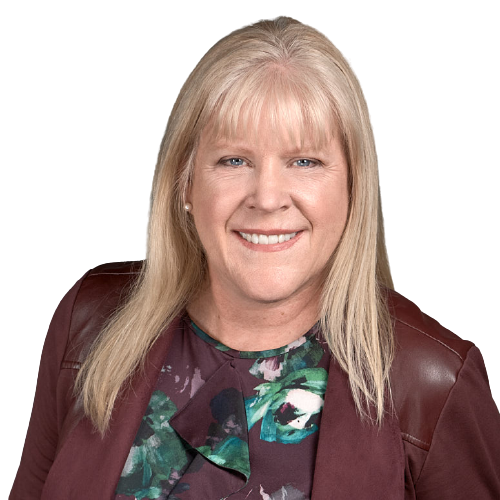 A woman wearing a floral shirt and a maroon jacket is smiling for the camera.